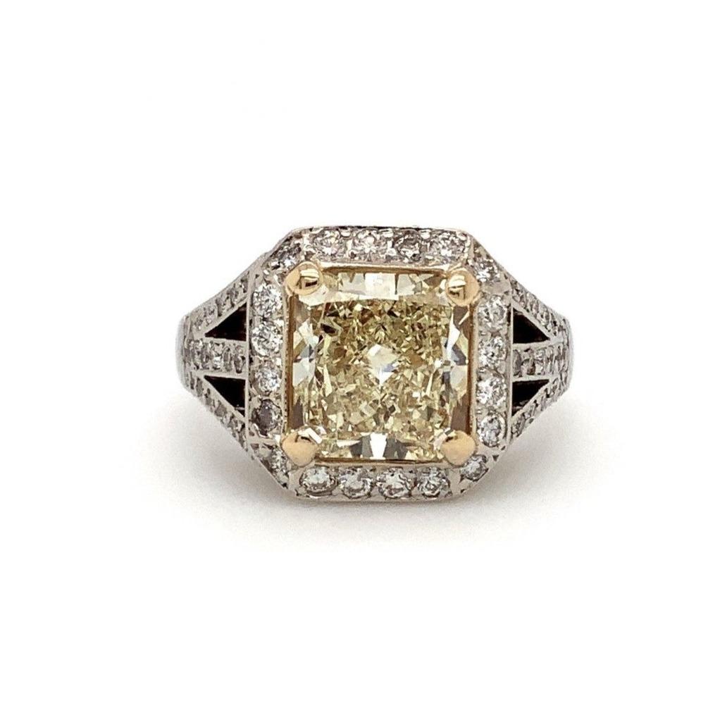 This Fancy Light Yellow Radiant Cut and White Diamond Engagement Ring is crafted from 3.89 cts. of 18K White and Yellow Gold and features a

GIA Certified 2.67ct Fancy Light Yellow Color VVS2 clarity Diamond at its center. The White Diamonds boast a