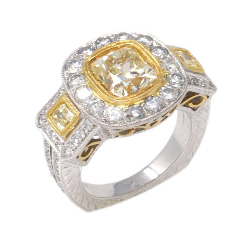 Ein einzigartiger Ring aus 18 Karat Gelb- und Weißgold, besetzt mit einem hellgelben Diamanten im Kissenschliff von 3,30 Karat (VS2), zwei gelben Diamanten im Kissenschliff von insgesamt 1,97 Karat (VS2) und seitlichen Steinen im Brillantschliff von