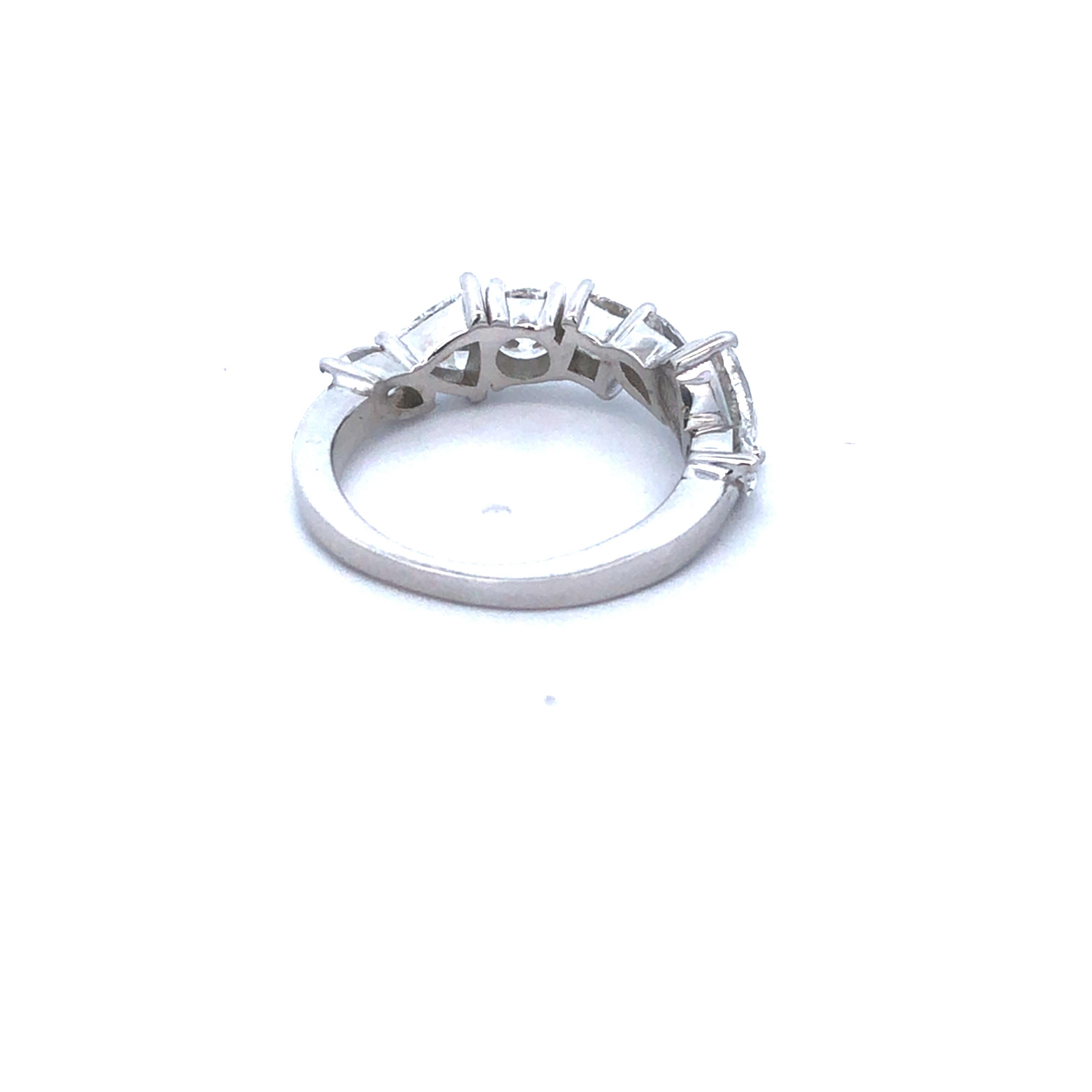 Dieser elegante Ring aus 18-karätigem Weißgold ist eine faszinierende Mischung aus Diamanten. Das Band zeichnet sich durch eine einzigartige Anordnung von mehrförmigen Diamanten aus - Trillionen-, Birnen-, Marquise-, Prinzessinnen- und runde