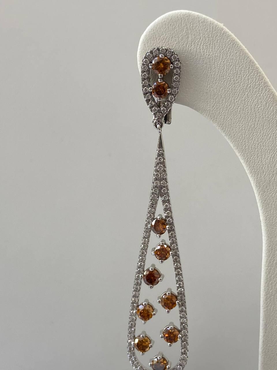 Fancy Orange Diamond Earrings Total Carat Weight 4.69 ct in White Gold 

The most elegant drop earrings you can find. They are set with magnificient 20 pieces of Fancy Orange Round Diamonds, which are fully surrounded by round colorless diamonds.