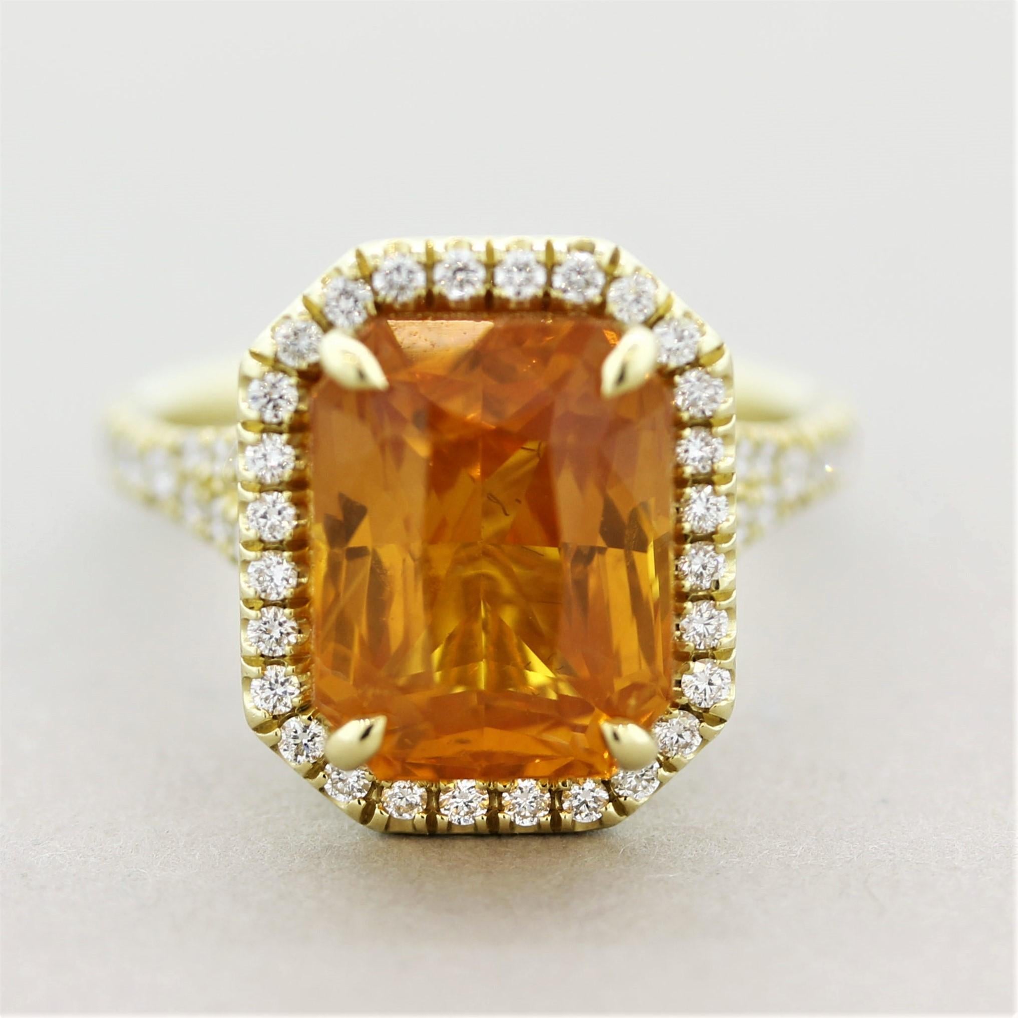 A fanciful ring featuring a 7.97 carat fancy colored sapphire. It has a bright vivid yellowish-orange color and is certified by the GIA as natural. It is accented by 0.50 carats of round brilliant-cut diamonds which halo the sapphire and run down