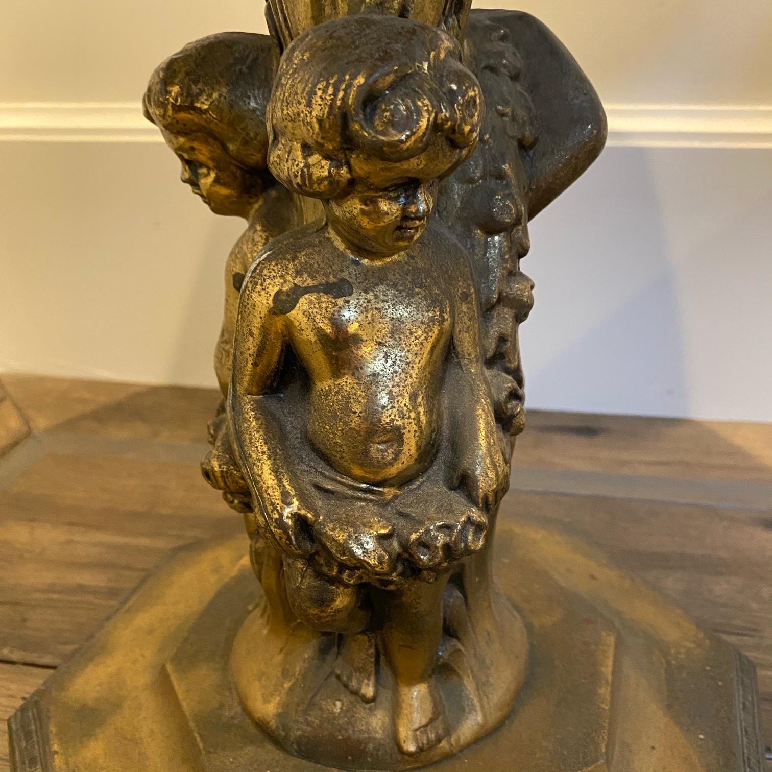 Pair of dramatic Italian Rococo style figural marble top cherub side tables having a beautiful weathered gilt metal patina and inset round Italian Carrara marble tops. Bottom is 11 x 11.
 