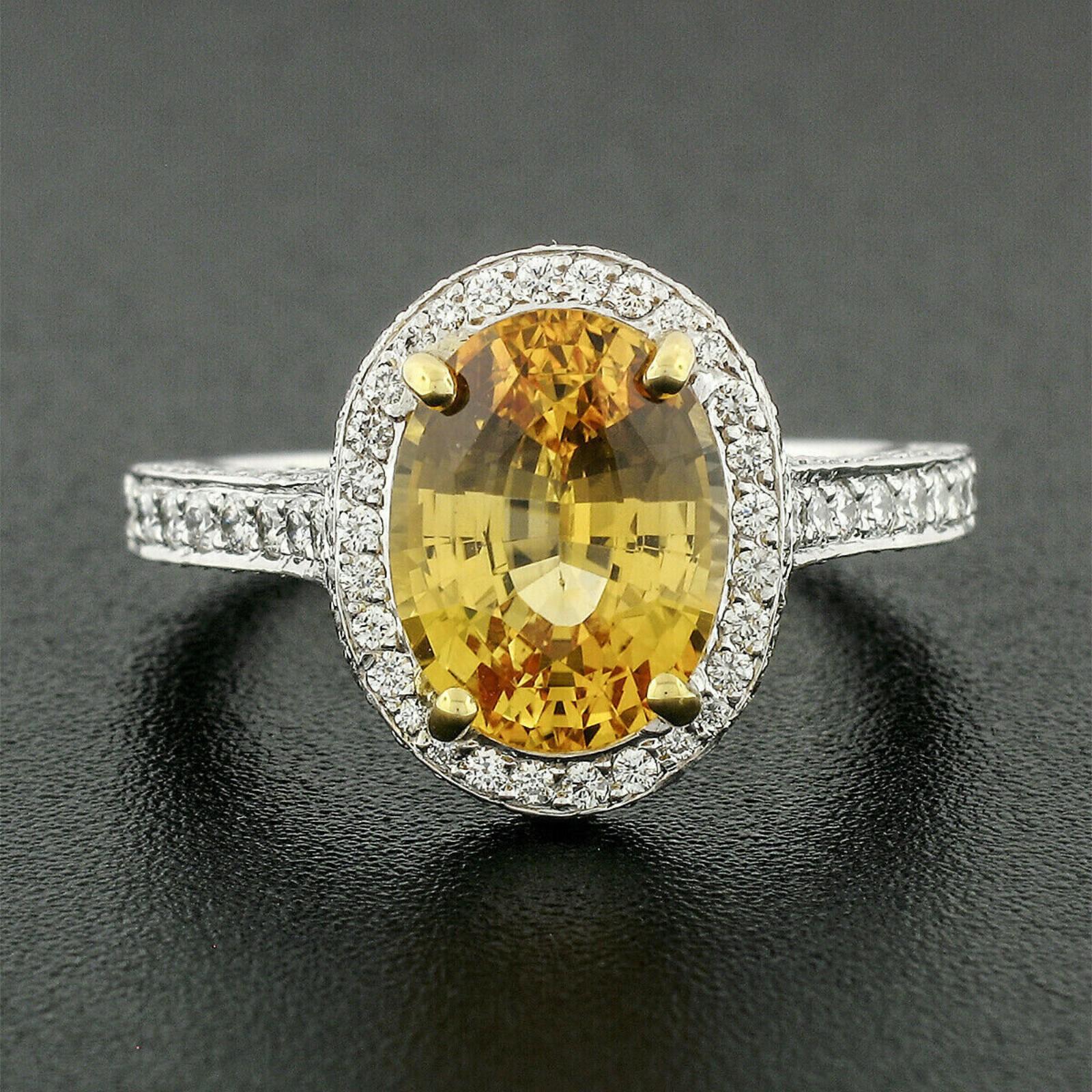 This magnificent yellow sapphire and diamond ring is crafted in solid platinum and features a GIA certified oval brilliant cut natural yellow sapphire. The 4.22 carats Ceylon sapphire solitaire sits at the center of a fancy halo design, floating