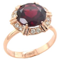 Bague cocktail fantaisie en or rose 18 carats avec halo de grenats rouges ronds et diamants