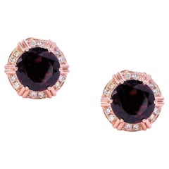 Clous d'oreilles fantaisie en or rose 18 carats avec grenats rouges ronds et halo de diamants