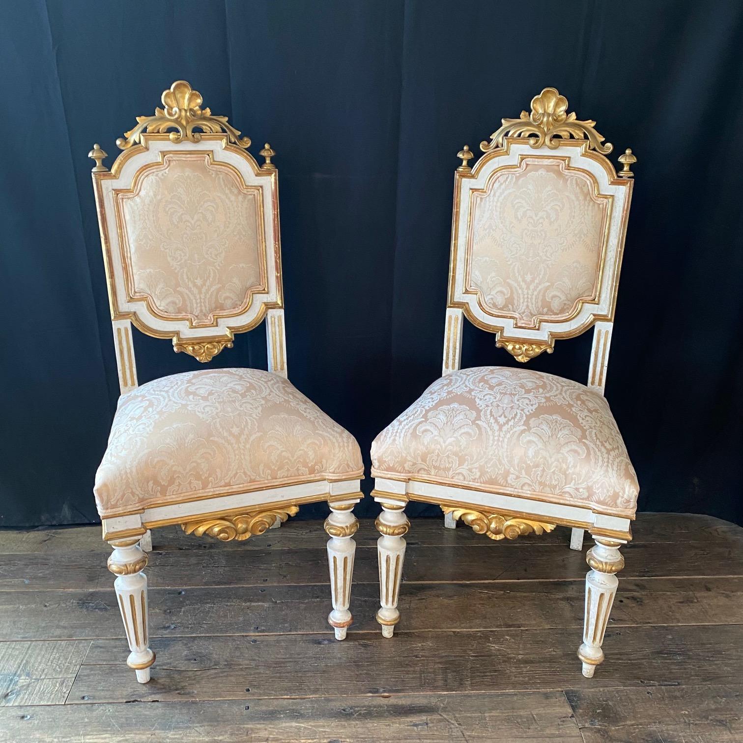 A set of four richly carved Italian, 19th century Venetian side or dining chairs with original rich gold gilt paint. The chairs stand on lovely reeded legs and skirt and seatback display beautifully carved and gilded crests of acanthus leaves and