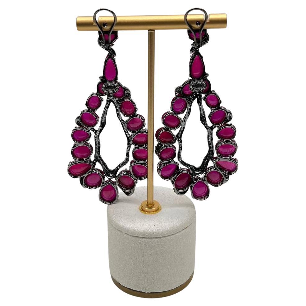 Realizzati con precisione, questi splendidi orecchini presentano vibranti rubini rosa rossi incastonati in un design delicato e intricato. Le pietre sono circondate da accenti scintillanti che creano un accattivante contrasto con i diamanti
