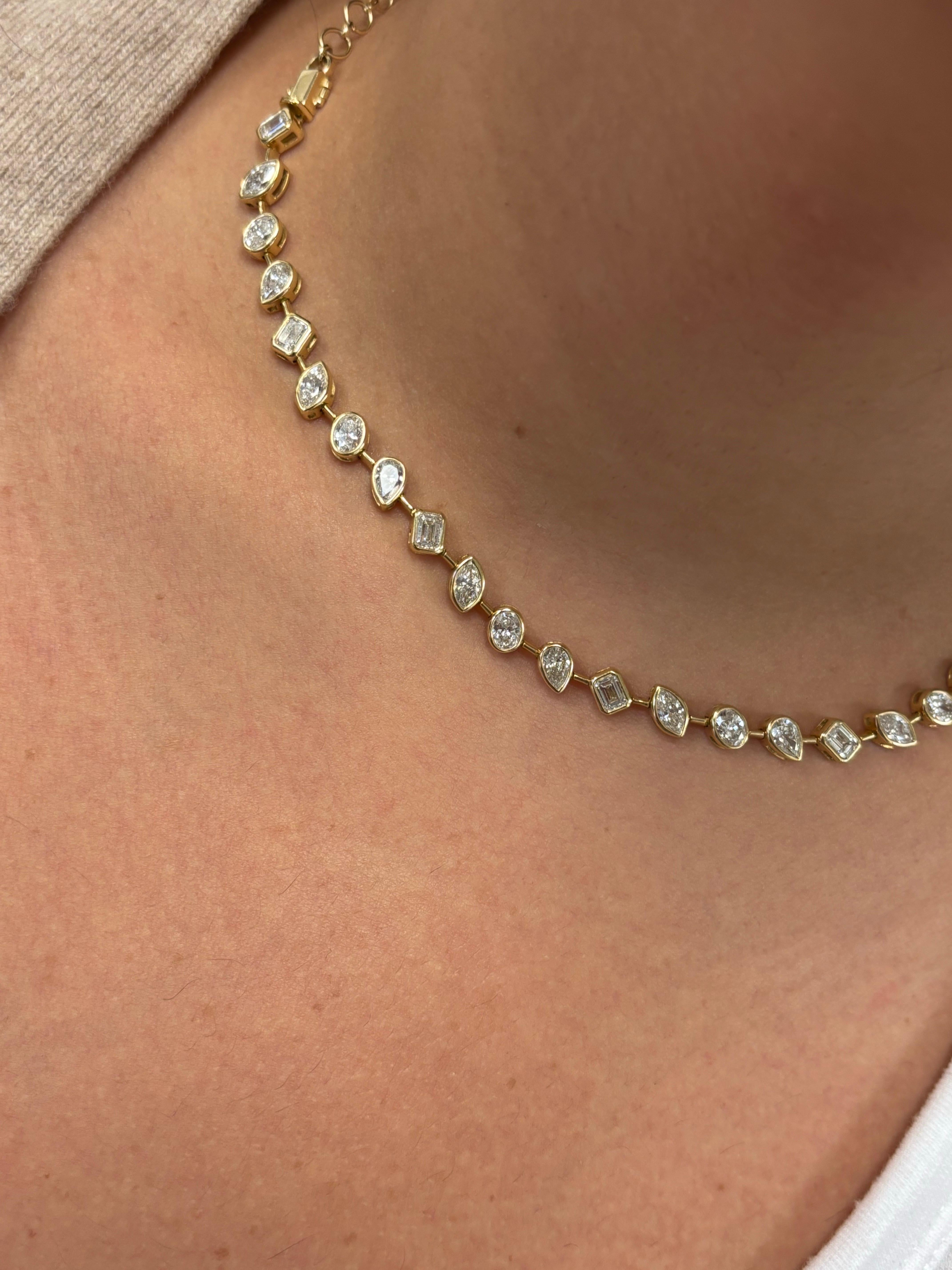 Mixed shape diamonds of emeralds, ovals, marquise and pears set on an 18K yellow gold bezel necklace. This necklace can be detached into a tennis bracelet. La couleur des pierres est F, la pureté est VS1. The weight of this piece is 9.57 Carats. The