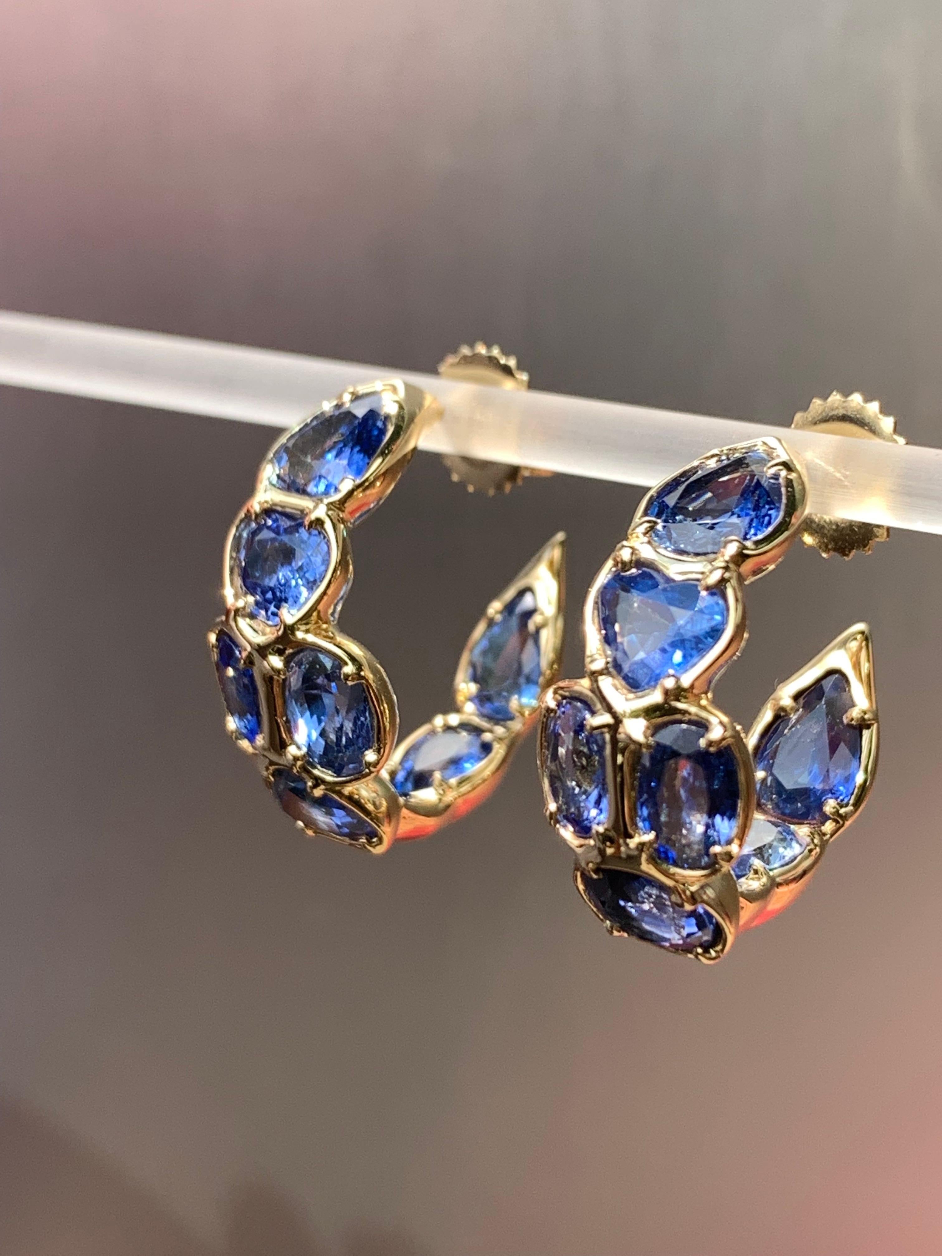 This stunning Blue Sapphire hoop earring is a blue sapphire lovers dream! It's small enough to be low key but the color will radiate however its worn. This is a one-of-a-kind 18kt yellow gold earring made from a selection of fancy cut sapphires