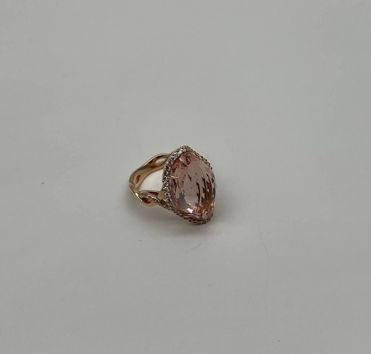 This captivating piece features a large, faceted shield kite Peach Morganite in a soft pink hue, set in a warm rose gold band. The gemstone is encircled by a delicate halo of sparkling diamonds, enhancing its brilliance and allure. The ring's design