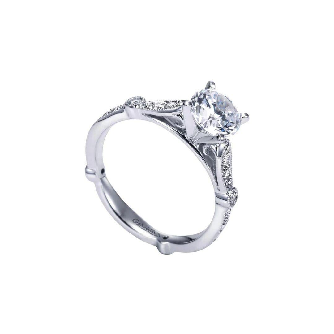 Fancy Solitaire Diamond Engagement Ring in 14k White Gold﻿. Tapered pave diamond shoulders are accented by a vintage inspired bezel set diamonds, which also repeat as an undercarriage motif underneath the center diamond. Center diamond weighs 0.37