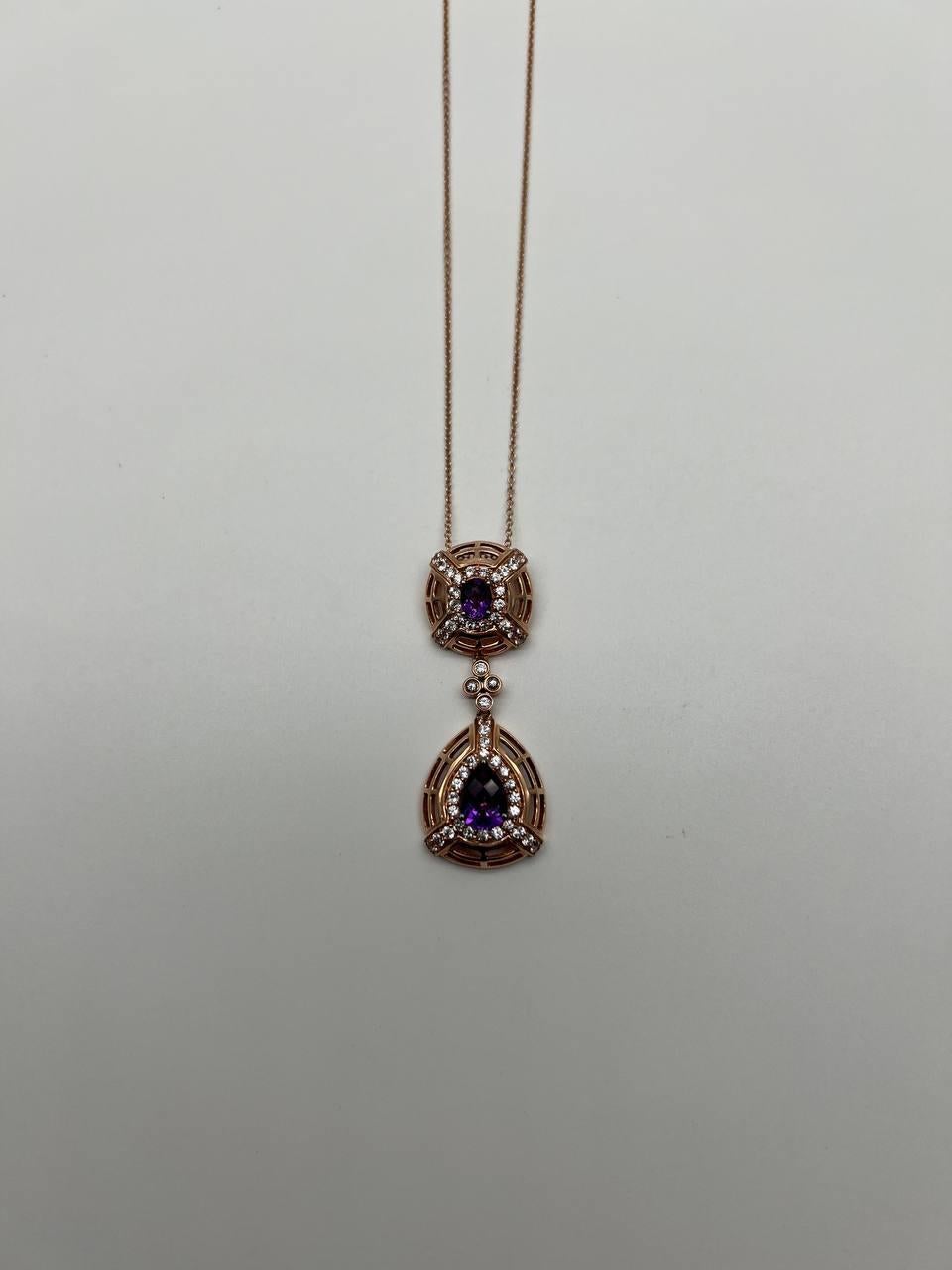 This exquisite pendant necklace is meticulously crafted in 14K Rose Gold. The necklace showcases a dual pendant design, each adorned with a central purple amethyst. The top pendant features a square frame with intricate lattice work, accented by