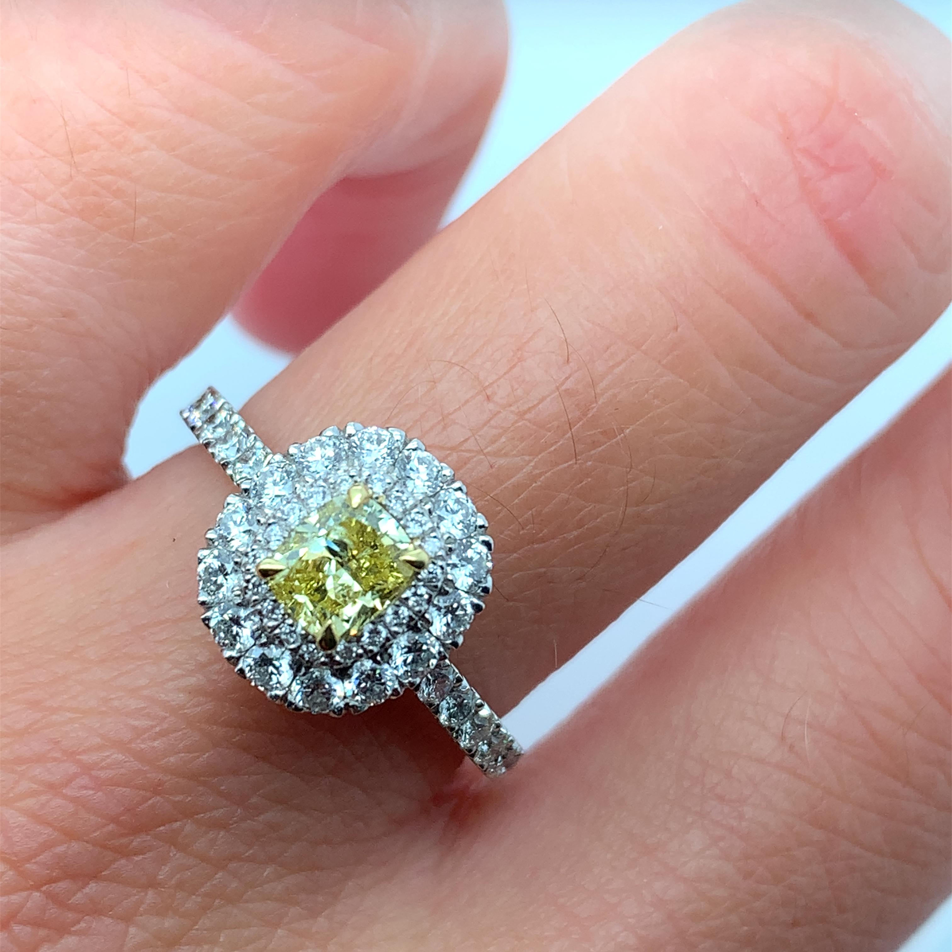This stunning platinum ring features a 0.50ct natural fancy vivid yellow cushion diamond, certified by IGI. The diamond is cushion in shape and has an excellent shape and rich yellow colour, with a vibrant double diamond halo F in colour and very