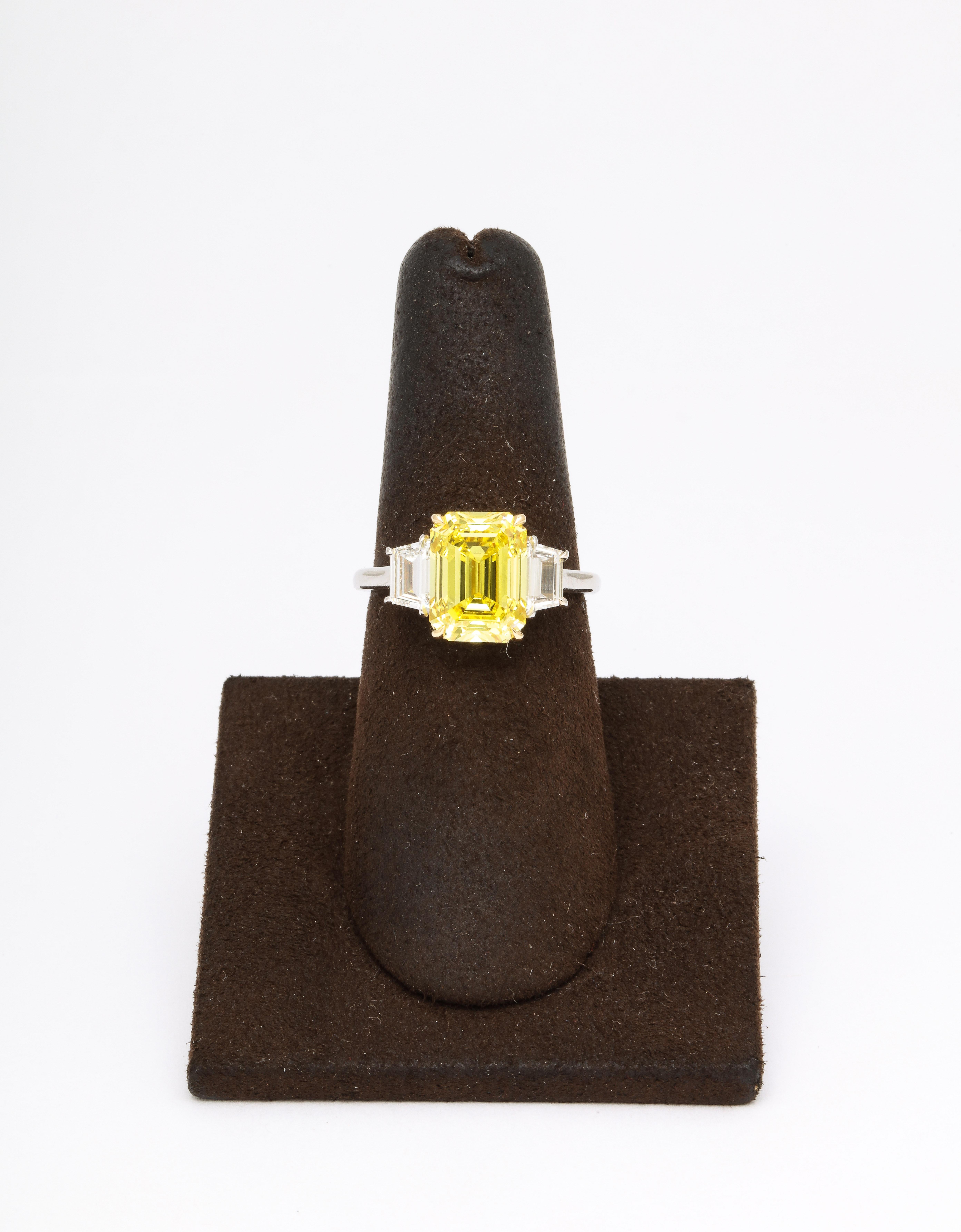
Rare and Unique!

GIA certified 4.12 carat Fancy Vivid Yellow, VS2, Emerald cut center diamond. 

Set with .64 carats of white step cut trapezoid diamonds. 

Beautiful rectangular shape! 

An Emerald cut, Fancy Vivid Yellow diamond with these