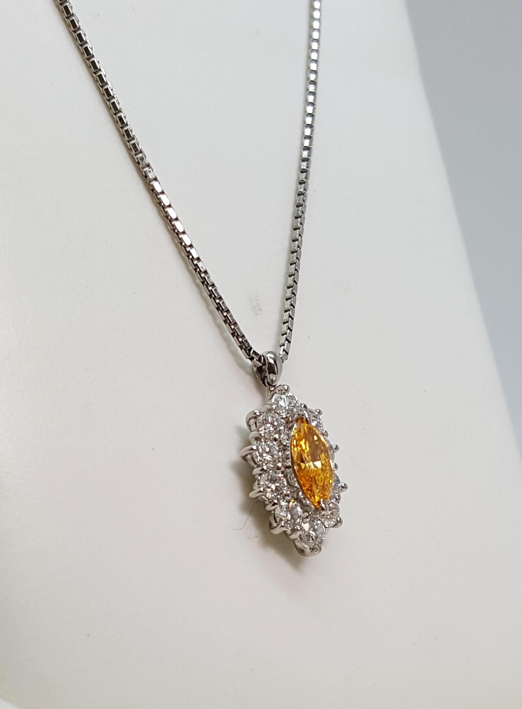 Questo eccezionale pendente è incentrato su un raro diamante giallo-arancio fancy vivido da 0,48 carati con taglio a marquise, certificato da GIA con una purezza SI1. La vibrante pietra centrale irradia una brillantezza ardente e una saturazione