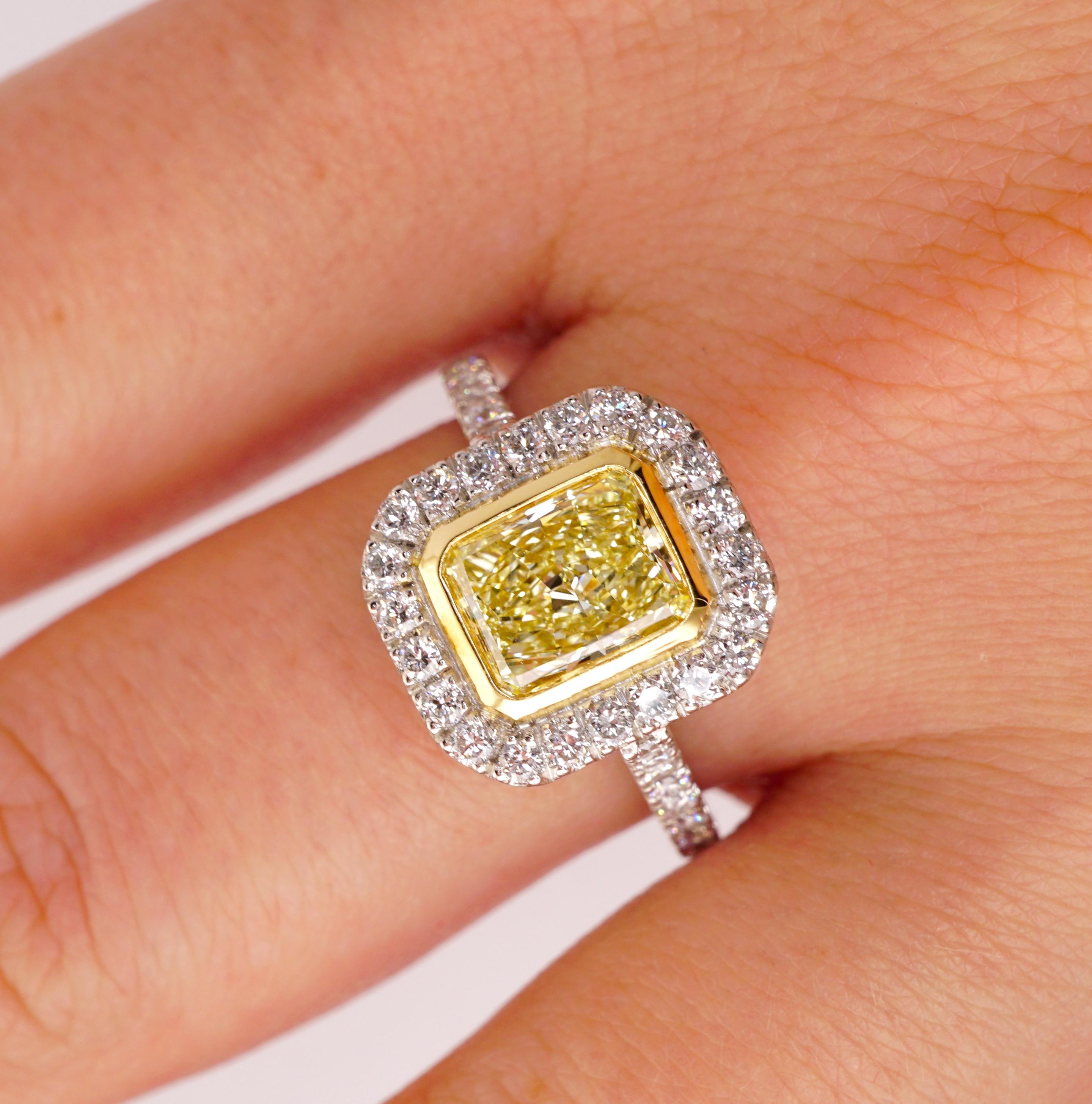 Diamond ring with EGL certificate, no. US59329301D. Details are: Center stone: 1.11ct/ VS2 radiant cut fancy yellow diamond, 7.1 x 5.7x 3.4mm. / Side stones: .90ct/ F-G VS1-SI1. Brilliant round diamonds. Total carat weight : 2.01ct. Metal: Platinum,