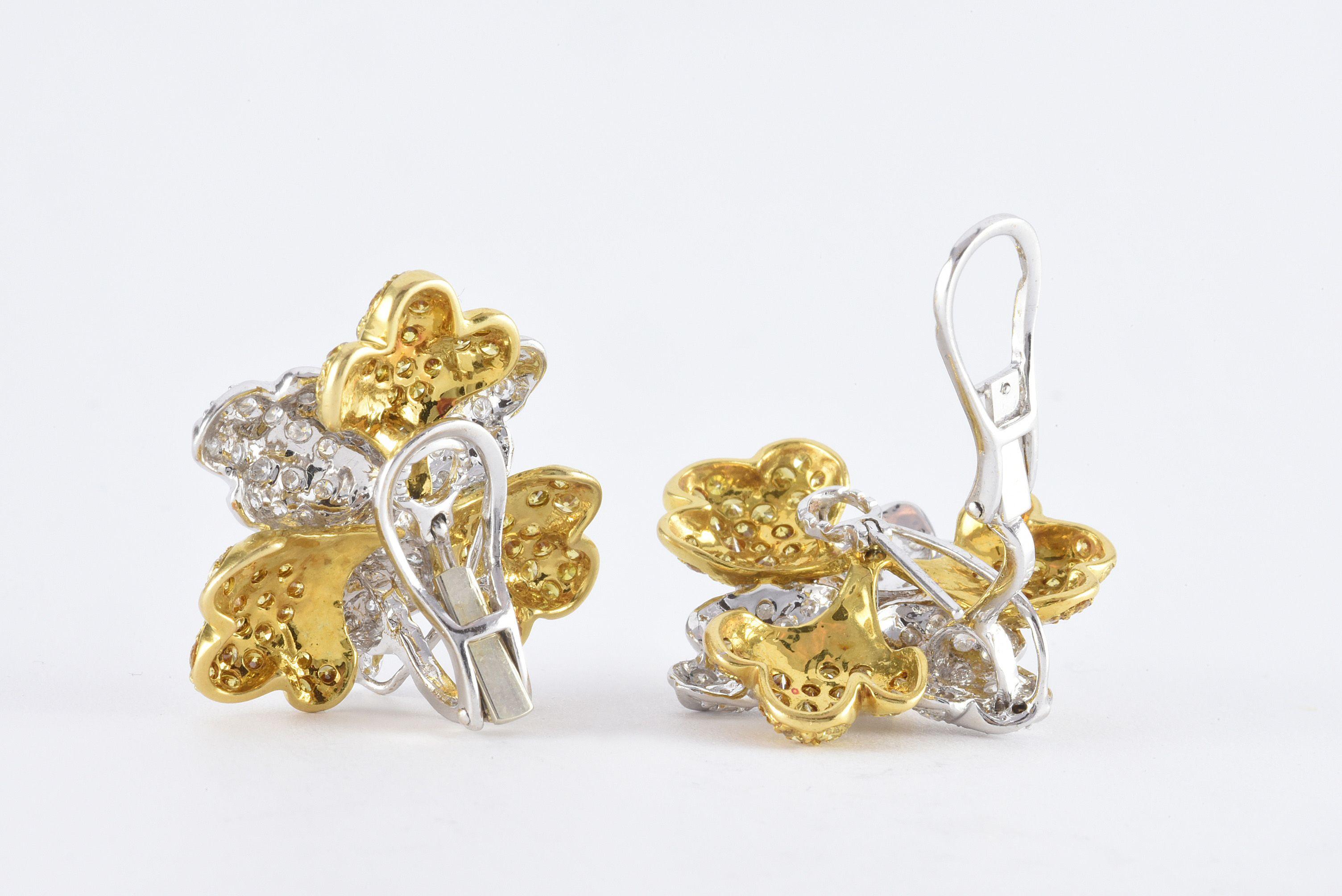 These bold flower ear clips feature fancy vivid yellow diamonds totaling approximately 3.00 carats and round white diamonds totaling approximately 2.00 carats, FG color, VS clarity set in 18kt white and yellow gold and secured with omega backs. For