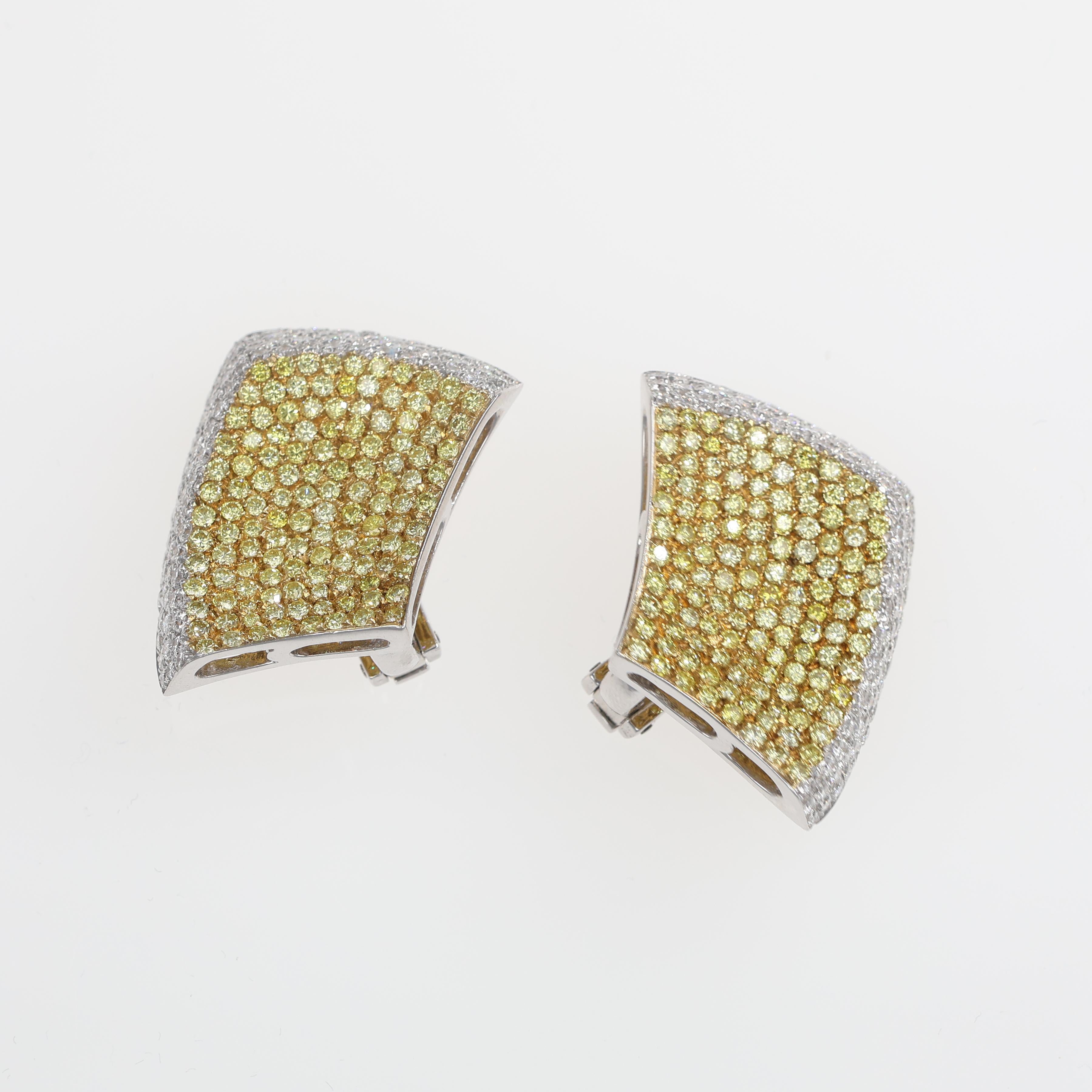 Elegant 18kt white gold stud earrings featuring a captivating pavé of fancy yellow diamonds, framed by a delicate border of brilliant-cut white diamonds. The unique curvature of the design adds a modern yet timeless appeal, making them a