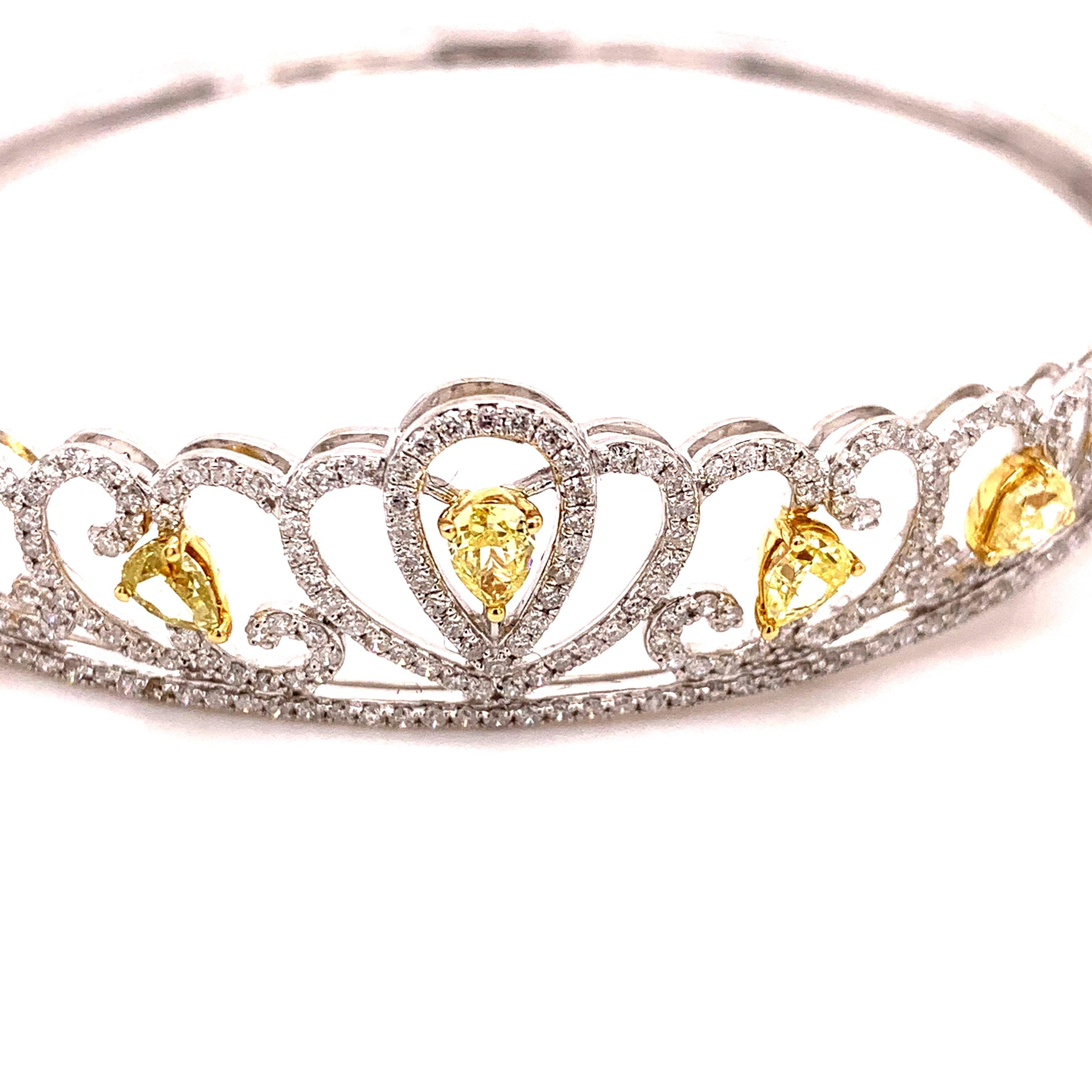 Stunning tiara design fancy yellow diamond bangle. Sparkling, pear brilliant cut, 0.91 carat, natural fancy yellow diamonds encased in open basket mounting with three bead prongs, accented with round brilliant cut diamonds. Handcrafted high polished