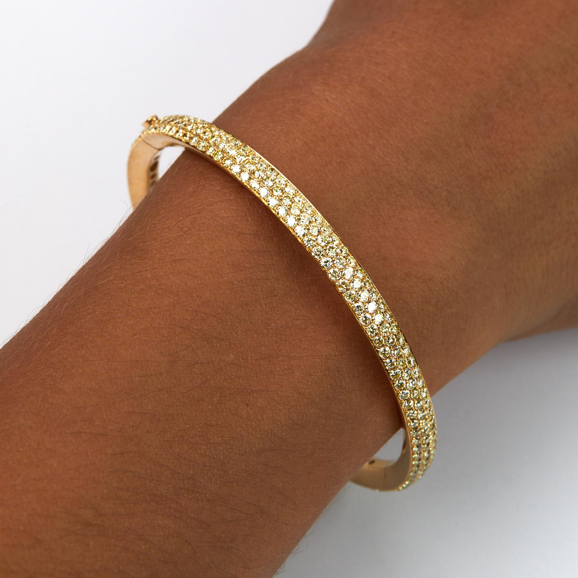 Fancy Yellow Diamond Bracelet with 5.93 carats of diamonds.  302 Brilliant round cut diamonds all individually hand pavé set into 18 karat yellow gold.  Hinged for easy on and off, and a small raised diamond is the clasp to open.  Set in 18 karat