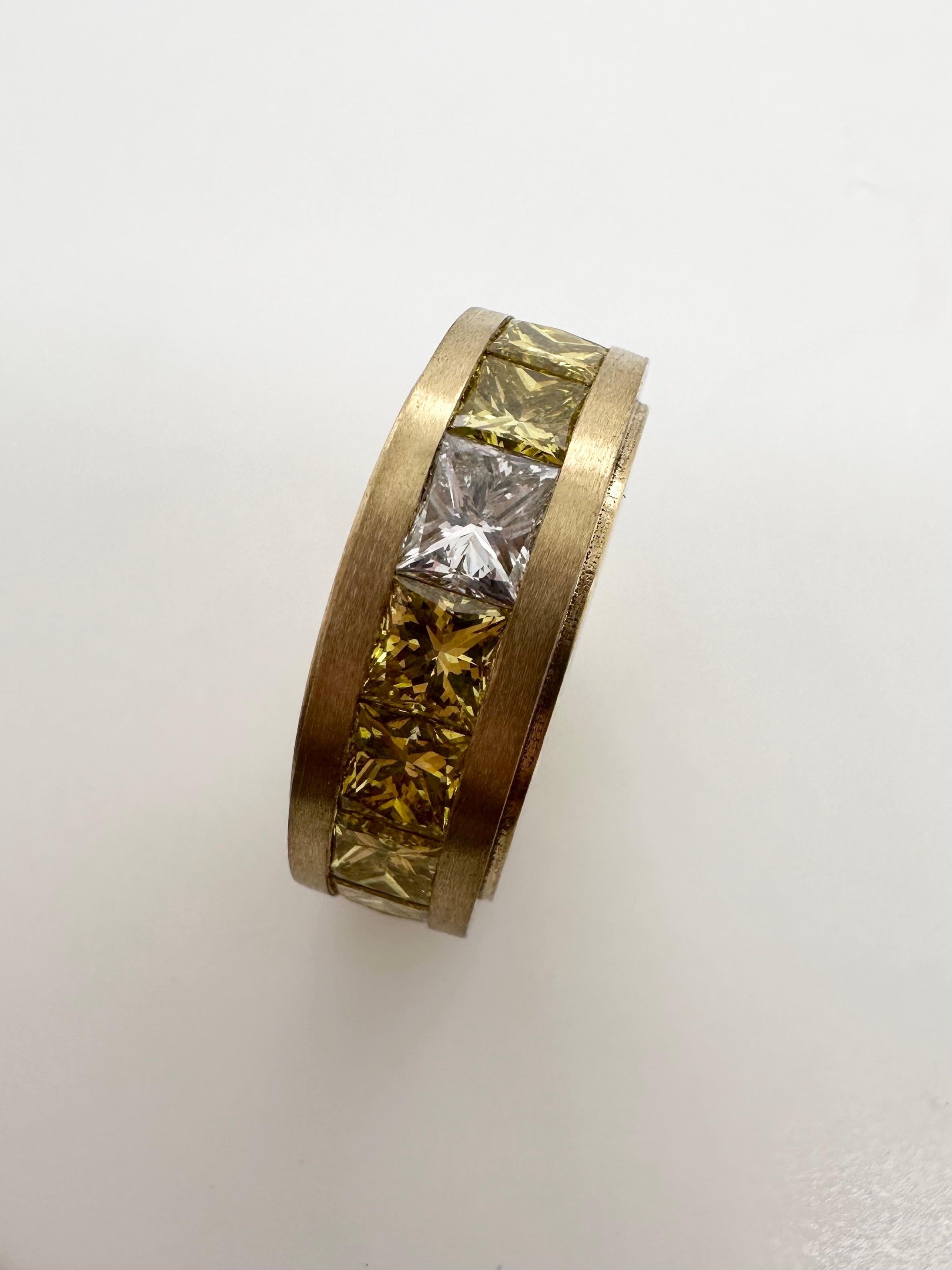 A very complex diamond ring to make! 
Made with fancy yellow diamonds all throughout except for top stone a white diamond, this is extremely popular right now to make one diamond in the eternity different color, this ring is so well made in 18KT
