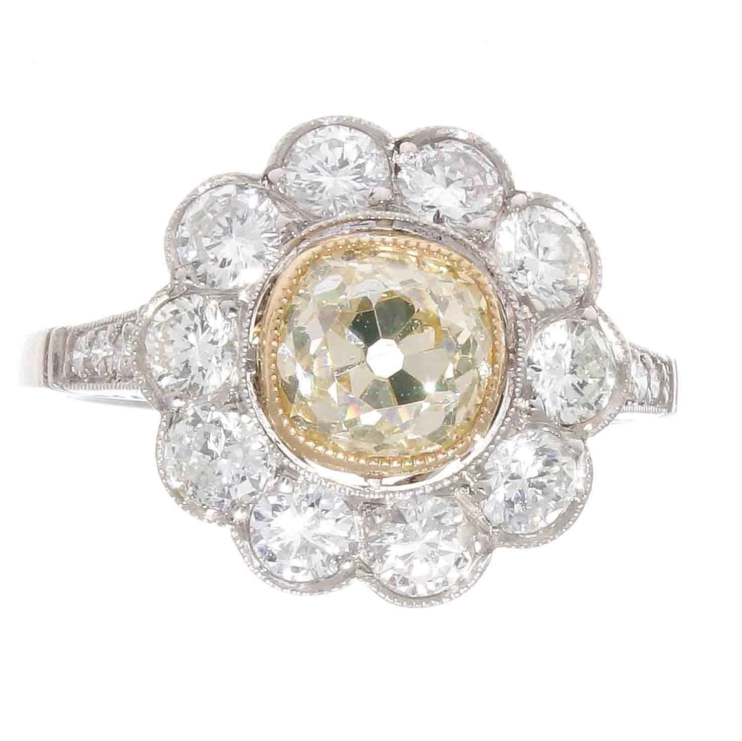 A blossoming daisy recreated through glistening gemstones. Featuring a pistol that is made up of a 1.20 carat old European cut diamond that is fancy yellow and is SI1 clarity. Surrounded by pure white petals of old cut colorless diamonds. Hand