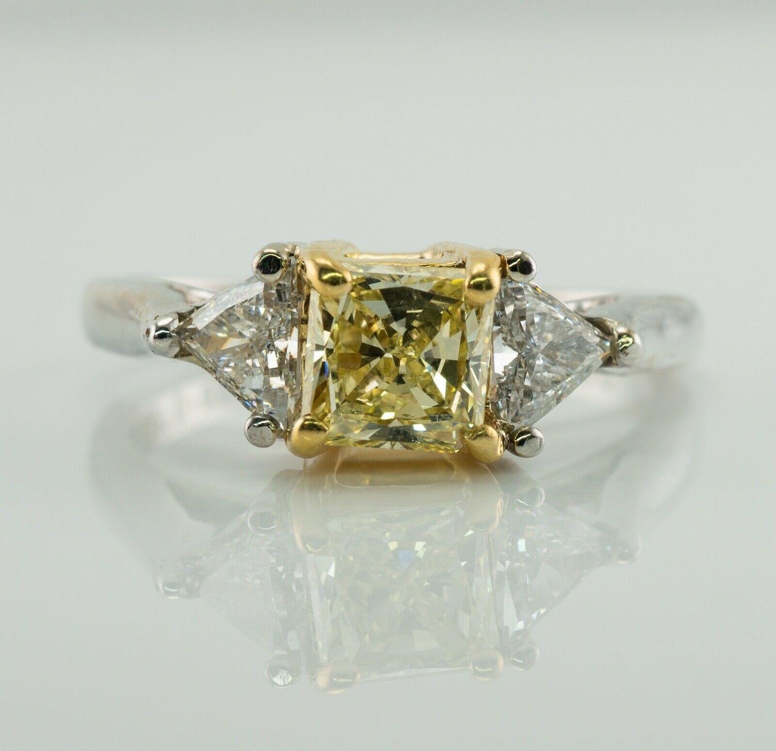 This beautiful estate engagement ring is crafted in solid 18K White Gold.
The center princess cut natural fancy yellow Diamond is .65 carat of VS1 clarity.
Two side trillion cut diamonds are .27 and .33 carat of SI2 clarity and H color.
The top