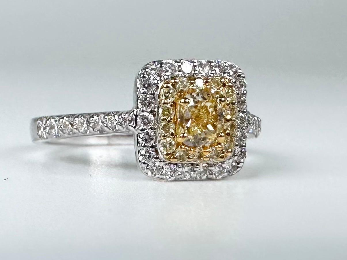Beautiful engagement ring in 18Kt yellow gold with natural fancy yellow diamond in the cener surrounded by doubel halo of diamonds.

GOLD: 18KT gold
NATURAL DIAMOND(S)
Clarity/Color: VS/G
Carat:0.19ct
Cut:Round Brilliant
NATURAL YELLOW