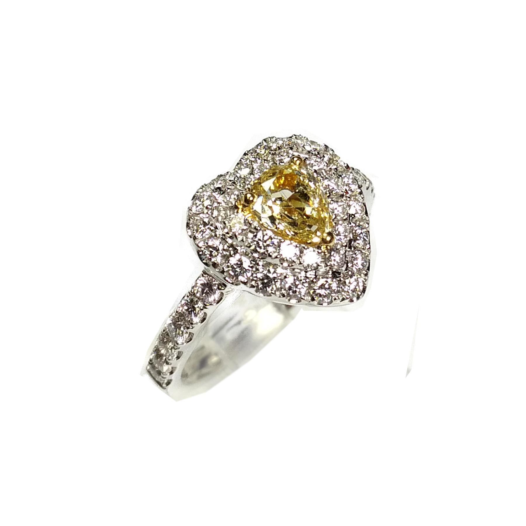 Fancy yellow 0.57 carat diamond ring. Natural fancy yellow pear brilliant cut diamond, set in high profile basket mount with 3 yellow gold bead prongs. Handcrafted heart shape design in round brilliant cut diamonds, accented with diamond shank.