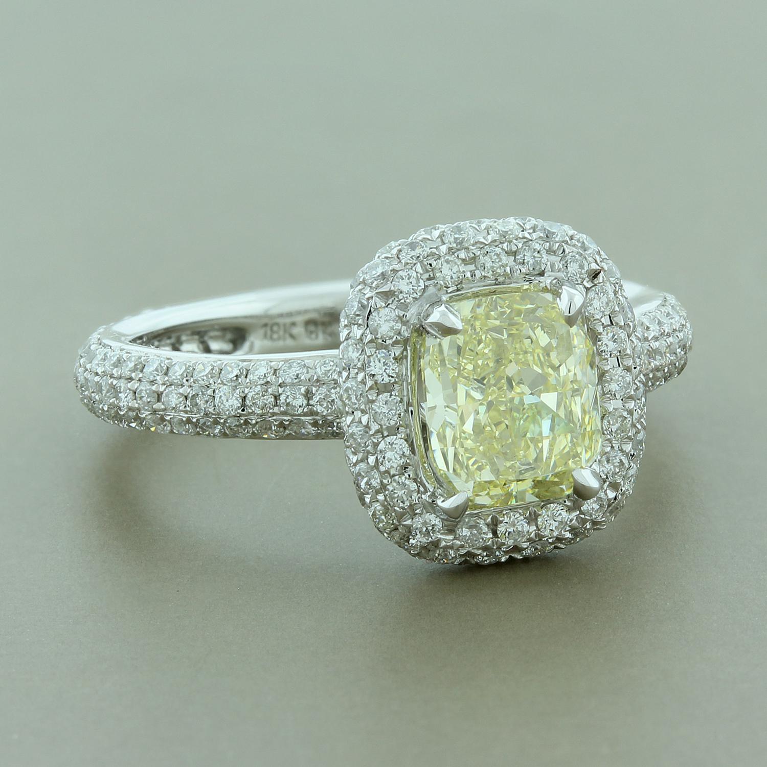 A unique engagement ring for a one-of-a-kind woman! This 1.32 carat fancy yellow emerald cut diamond is haloed by round cut glistening white micro-pave set diamonds. The rest of the 18K white gold ring is micro pave set with brilliant cut diamonds
