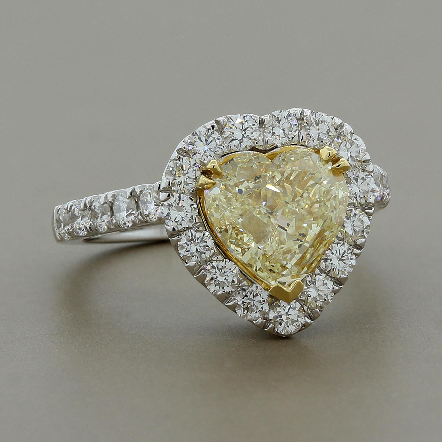 When you’re at a loss for words this spectacular ring is all you need! A 2.01 carat fancy yellow heart cut diamond is set in 18K yellow gold and is haloed by 1.04 carats of round cut white diamonds set in 18K white gold.  We love the heart shape for