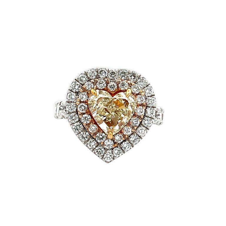 This exquisite heart-shaped ring is sure to capture your heart with its breathtaking array of diamonds that shimmer and shine with every twist and turn. The centerpiece of this piece is a remarkable 2.80-carat yellow diamond that has been expertly