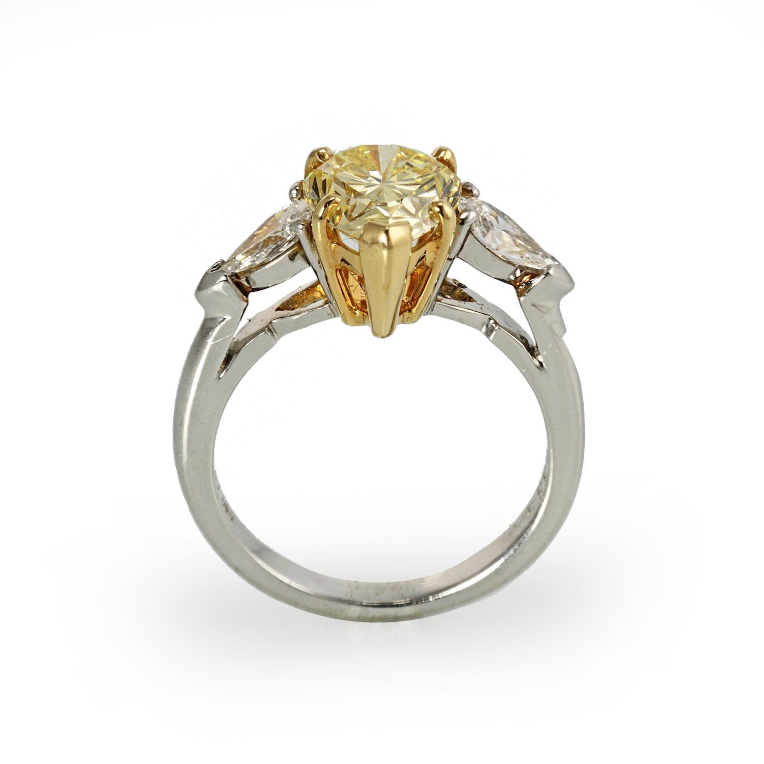 This Pear Shape Natural Fancy  Intense Yellow is flanked by 2 colorless side pear shape diamonds.  This ring is something different. Yellower than a Fancy Yellow its intense color vibrates with brilliance. If you are looking for a natural Fancy