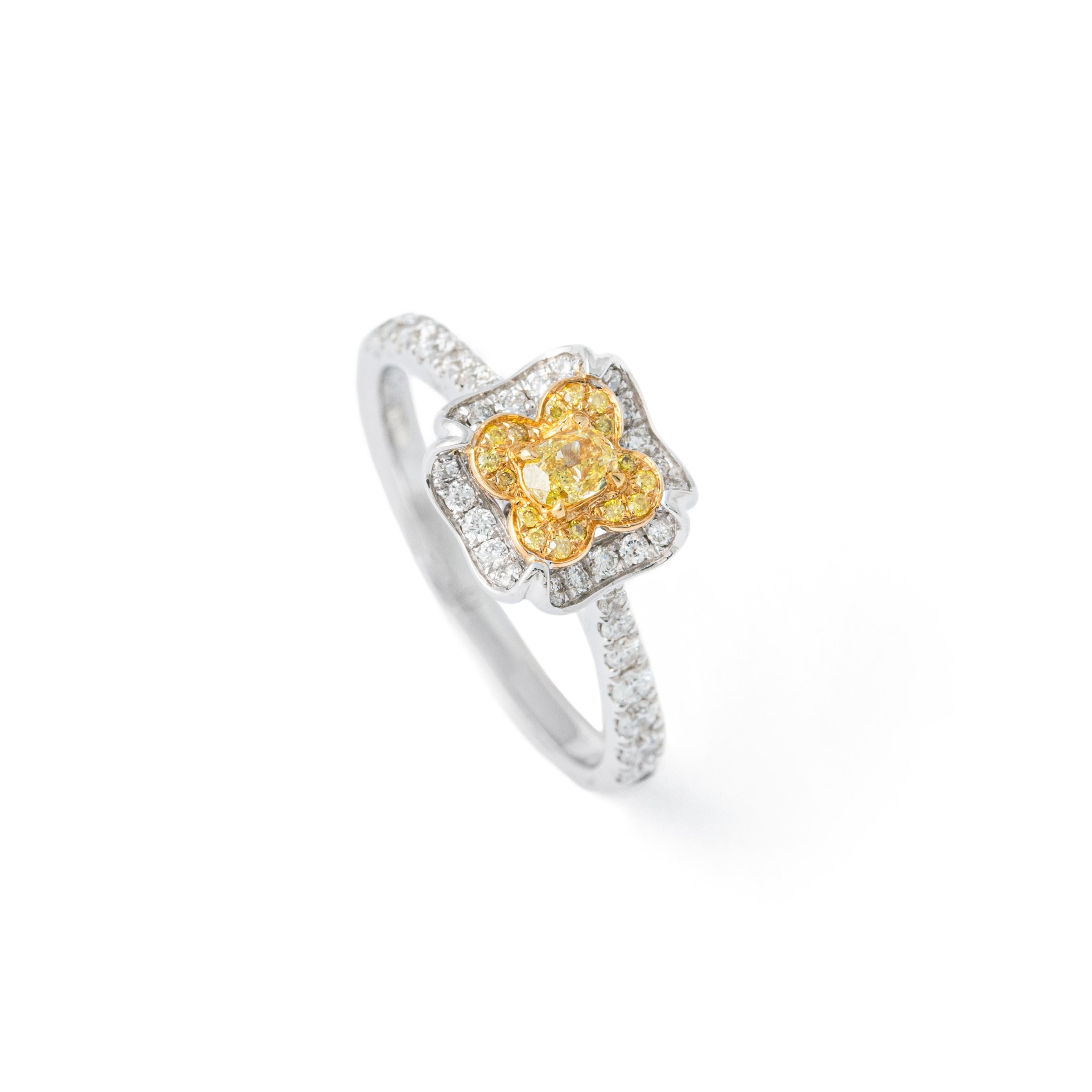 Fancy Yellow 0.10 carat Oval natural Diamond surrounded by 50 round cut Diamonds 0.37 carat total, estimated F / VS.
18K Gold Ring.
