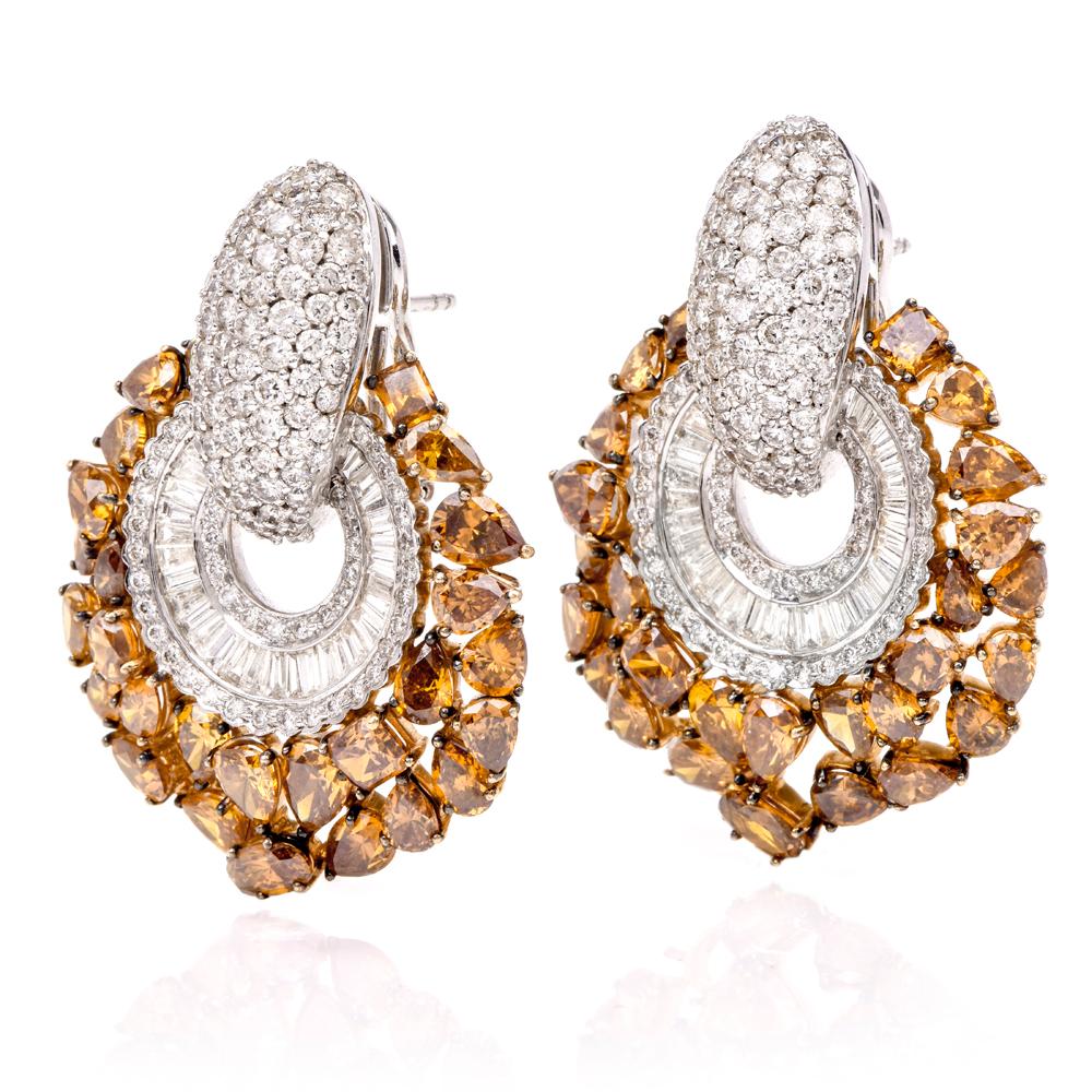 These opulent fancy diamond earrings are crafted in a combination of 18 karat white and yellow gold, weigh 31.3 grams and measure 41 mm long and 30 mm wide. These earrings are adorned with an assemblage of teardrop and oval-shaped fancy yellow