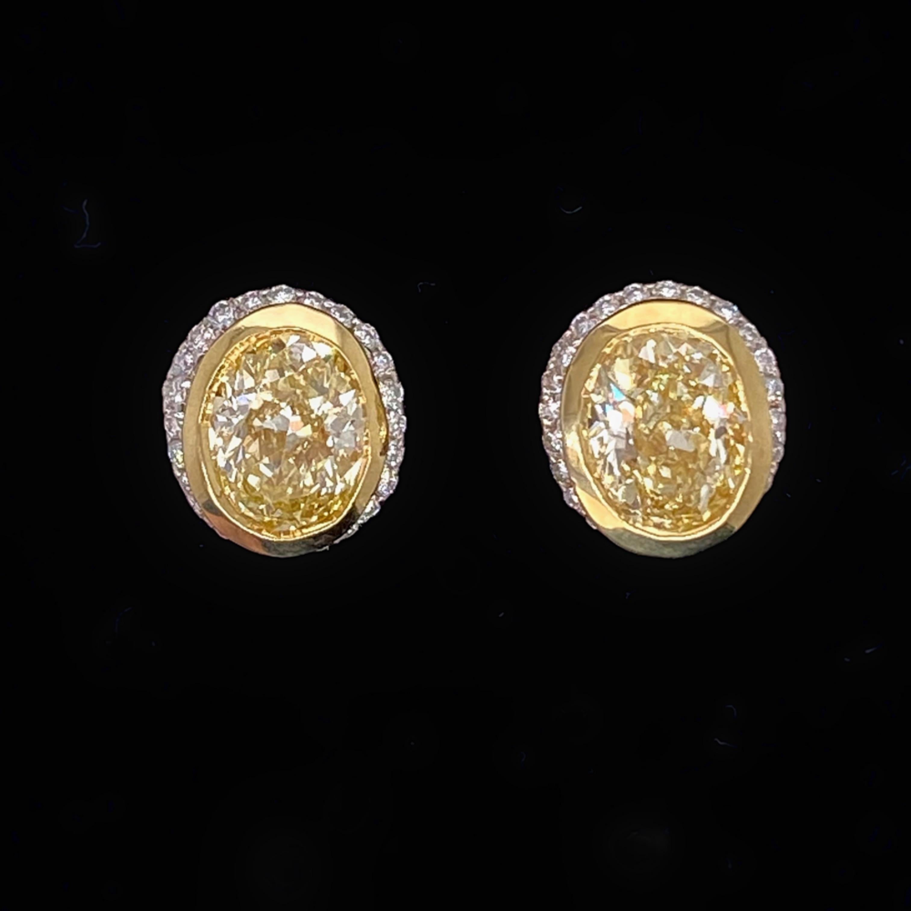 Fancy Diamond Oval Earrings
Style:   Bezel - Set with Micro Pave Diamond Halo
Metal:  18kt Yellow Gold and Platinum
Measurements:  8.75 X 7.42 X 6.27 MM
TCW:  2.25 tcw
Main Diamond:  2 Oval Cut Diamonds Bezel - Set in 18kt Yellow Gold 2.00 tcw
Color
