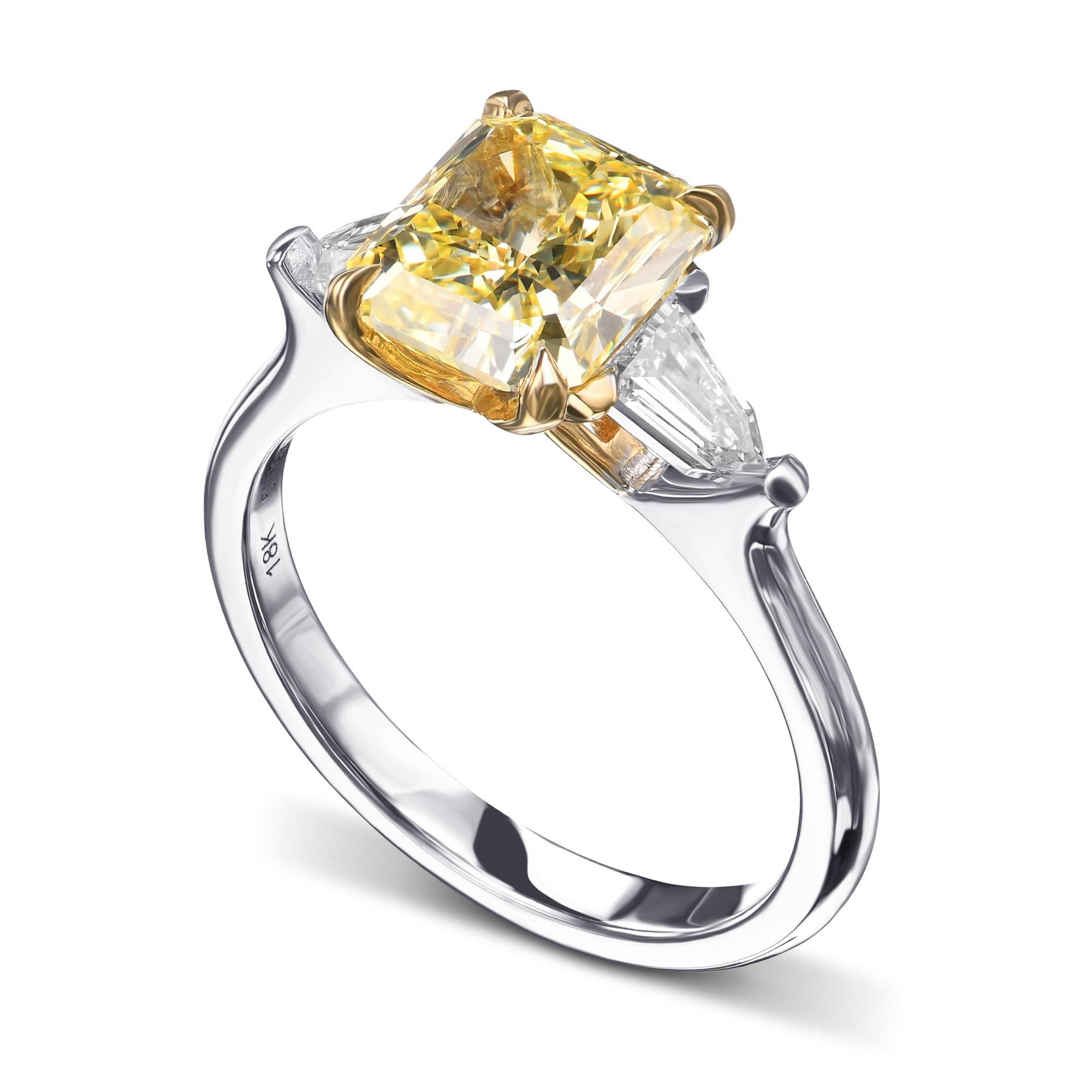 This Fancy Yellow three-stone diamond ring from the Secret Legacy Collection showcases the artistry and heritage of Leibish. At its center lies a 2.27-carat Fancy Yellow radiant-cut diamond, certified by GIA for authenticity and brilliance. Two