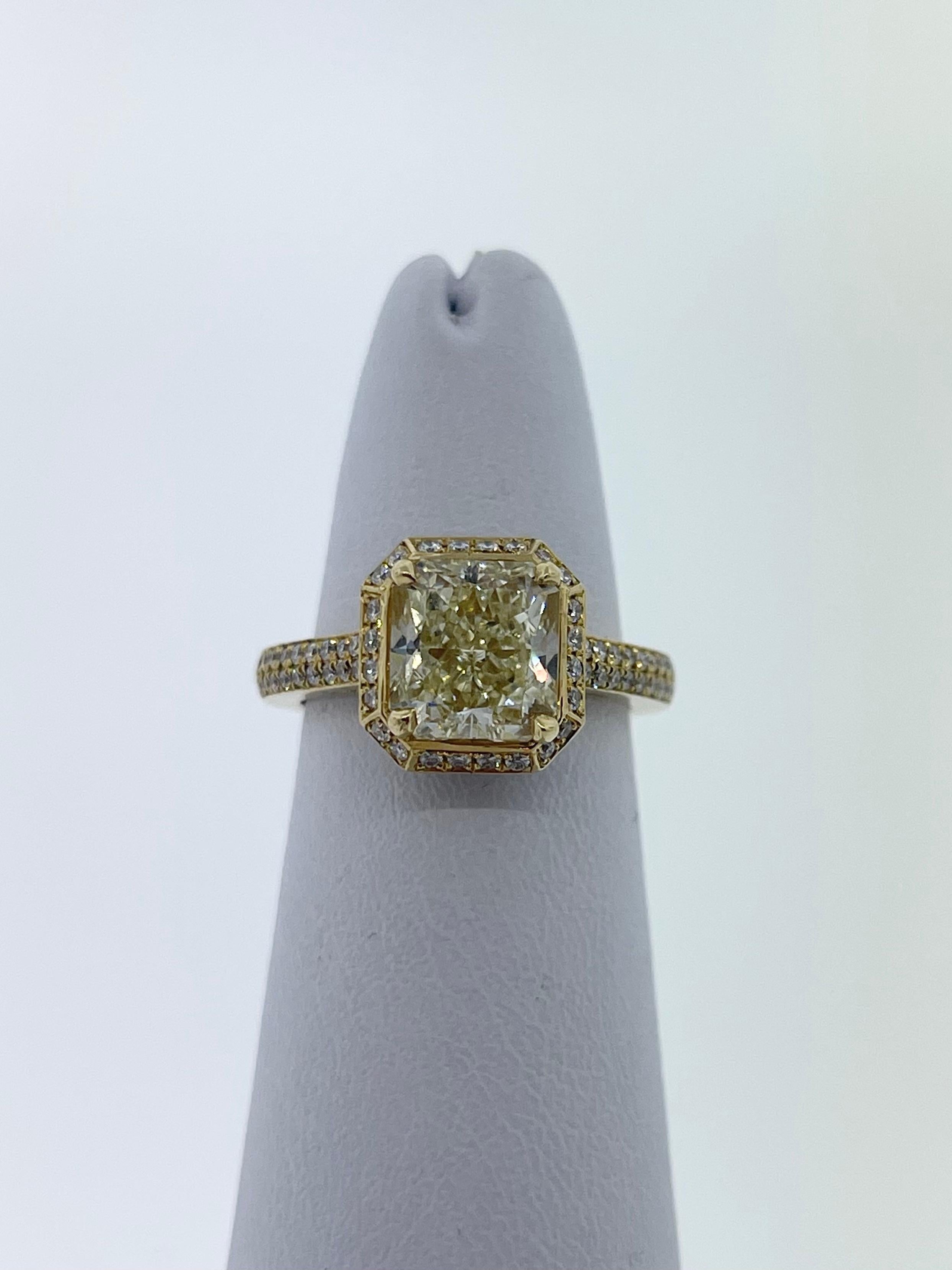 2.51ct Fancy Yellow Radiant Cut Diamond FY-VS1 in Quality Set in 18k Yellow Gold. 

The ring itself has 0.46 carat total weight of round diamonds going half way down the band and surrounding the center stone. 

The diamond is EGL Certified. 
