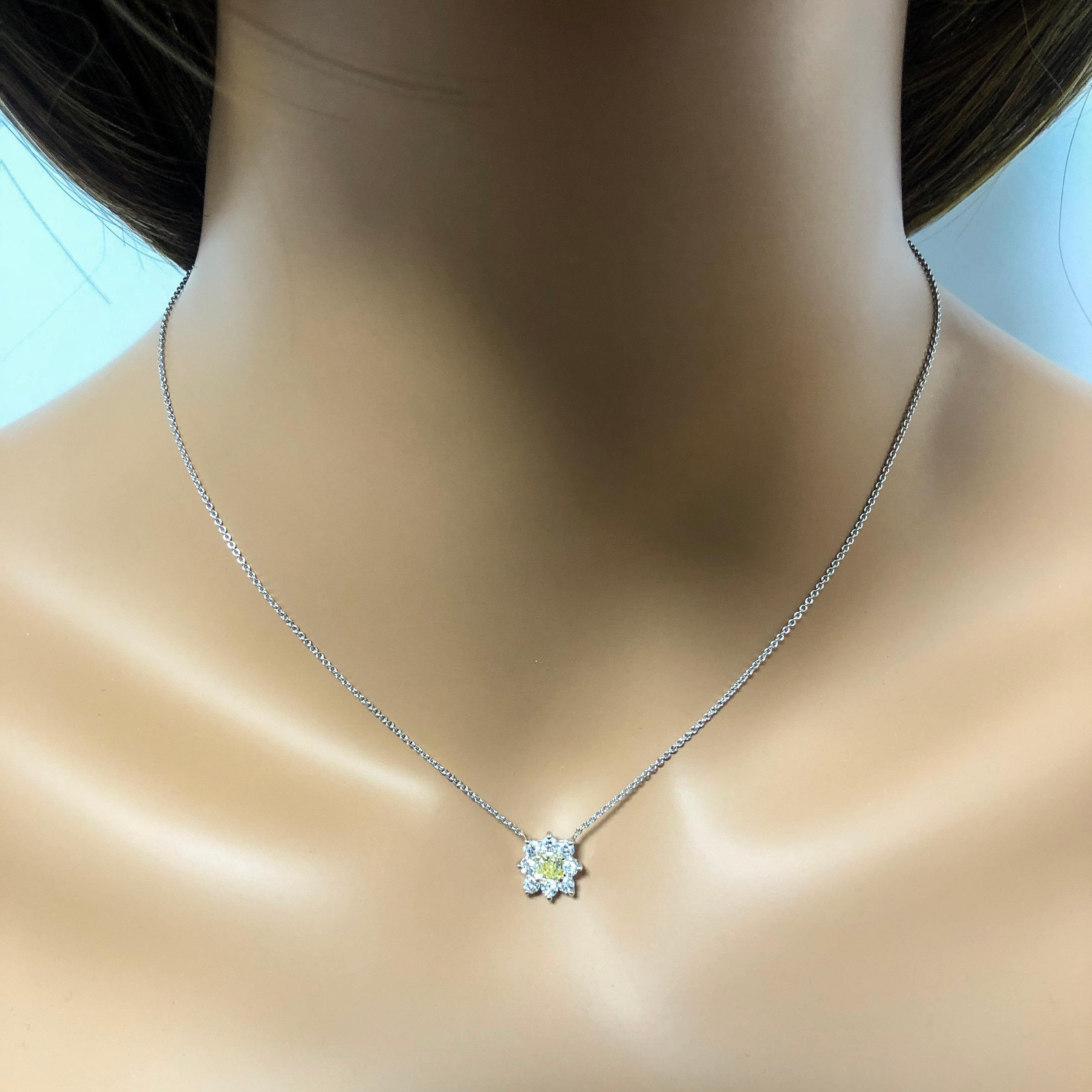 An amazing pendant necklace perfect for the summer. Features a color-rich radiant cut diamond center weighing 0.30 carats; surrounded by sparkling round diamonds weighing 0.53 carats total set in an intricate starburst design. A versatile piece