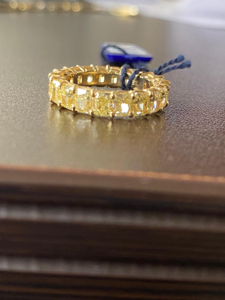 Fancy yellow radiant cut diamonds set in 18K yellow gold. The total carat weight of the ring is 6.79 Carats. Each stone weighs approximately 0.33 to 0.35 carats. The yellow stones are VS1 in clarity. The ring is a size 6.5.