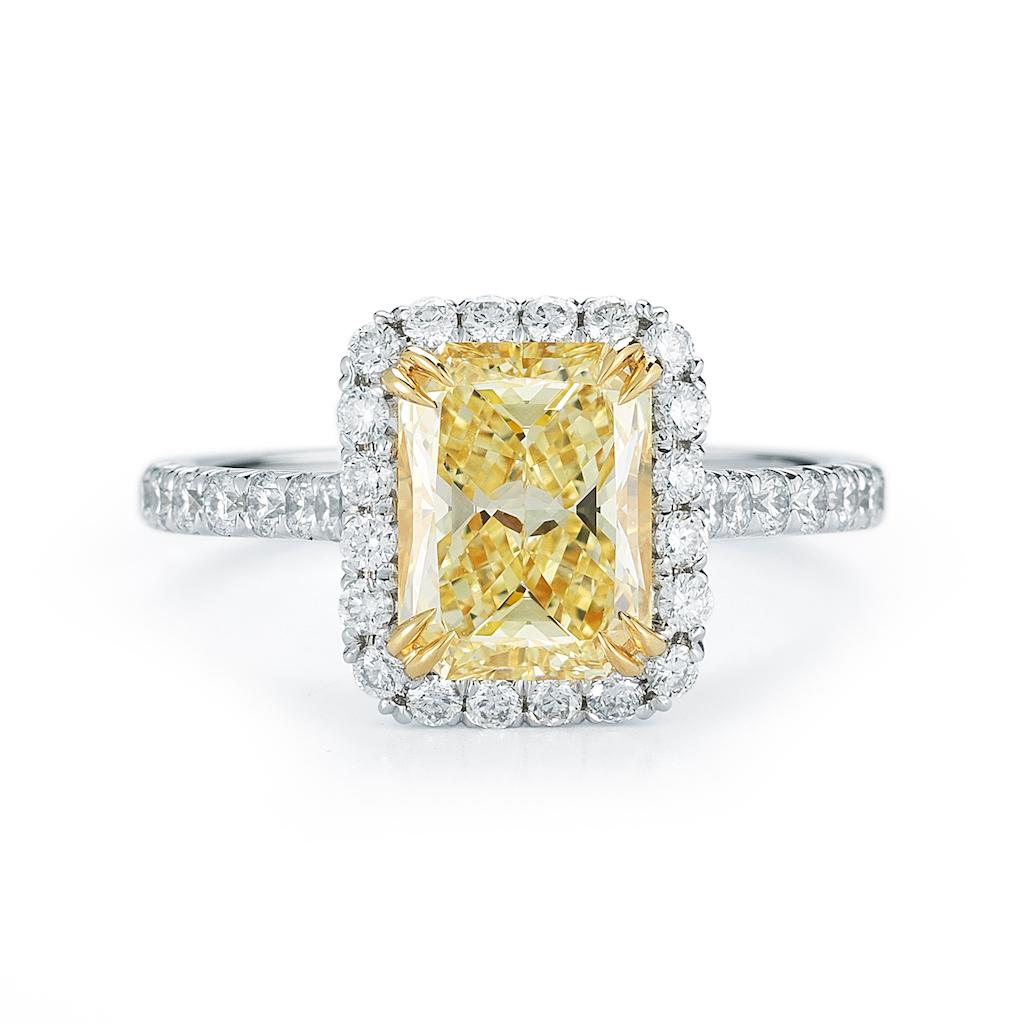 Setzen Sie ein Zeichen mit diesem atemberaubenden Verlobungsring mit gepflasterten Diamanten. Mit dem seltenen und ach so gelben natürlichen Diamanten im Fancy-Radiant-Schliff werden Sie sicher der Star der Show sein. Seien Sie jederzeit und überall