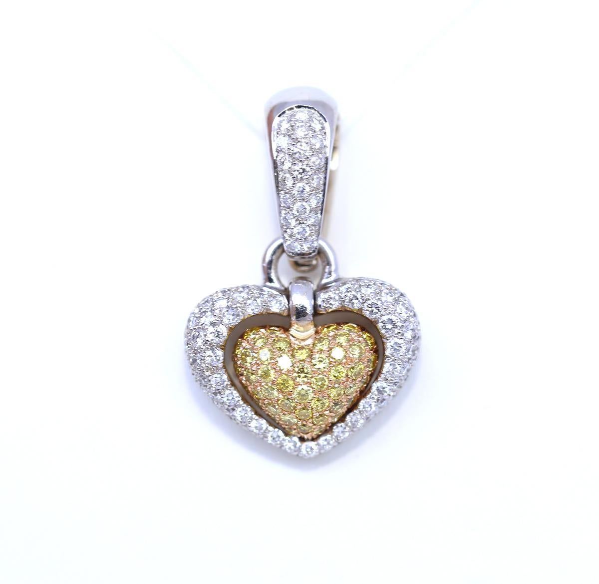 Fancy Yellow and White Diamonds Heart-shaped Pendant, Italy. 18 Karat White Gold.
Fancy Yellow Diamonds forming a shape of a heart is set freely within a bigger heart shape with fine white Diamonds. A heart within a heart moves freely with the