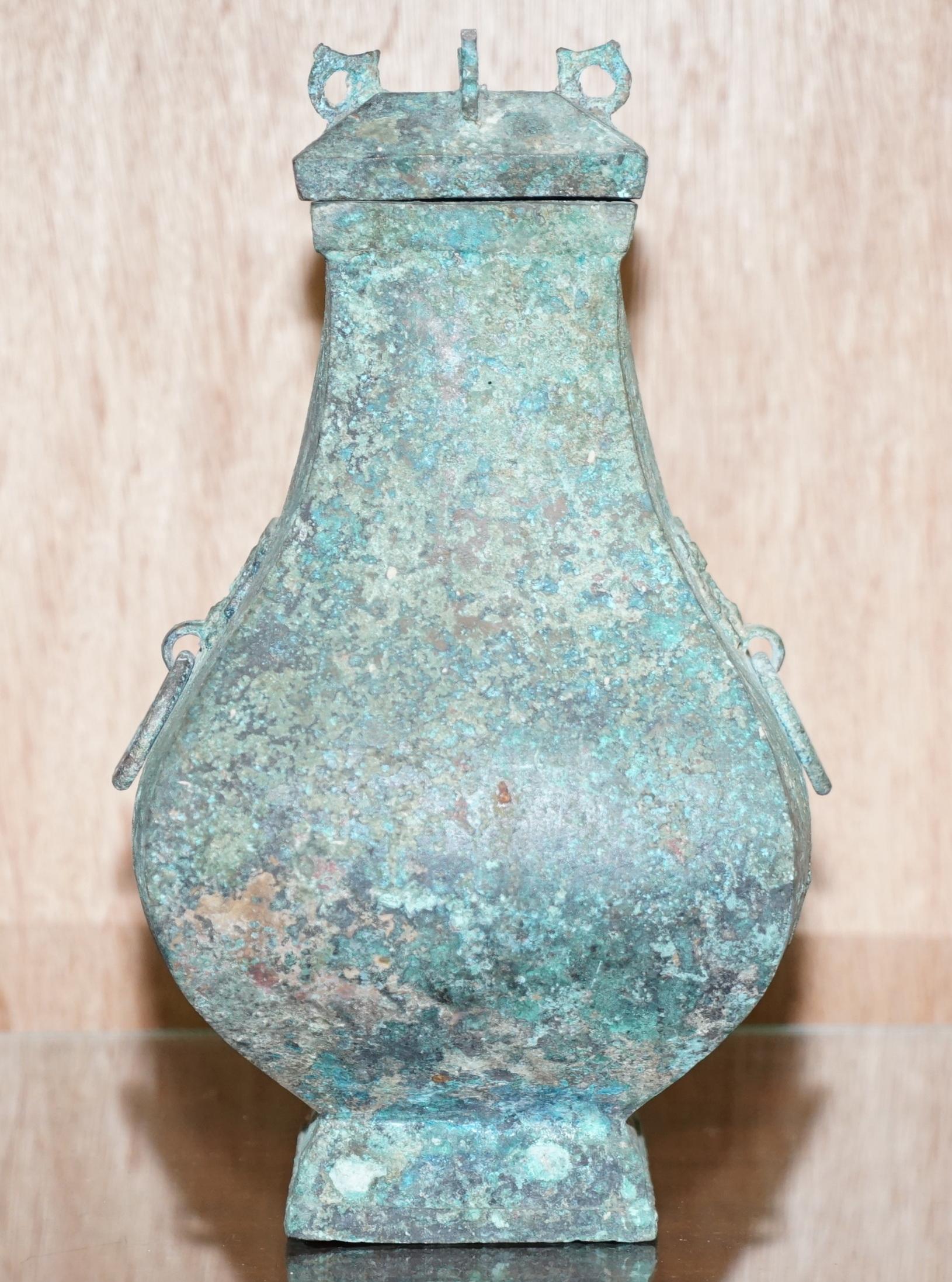 Nous avons le plaisir d'offrir à la vente ce vase à vin rituel et son couvercle en bronze de qualité muséale, Fanghu, dynastie Han 206BC-220AD, avec des poignées en forme de masque Taotie - patine vert olive et roussâtre avec des taches