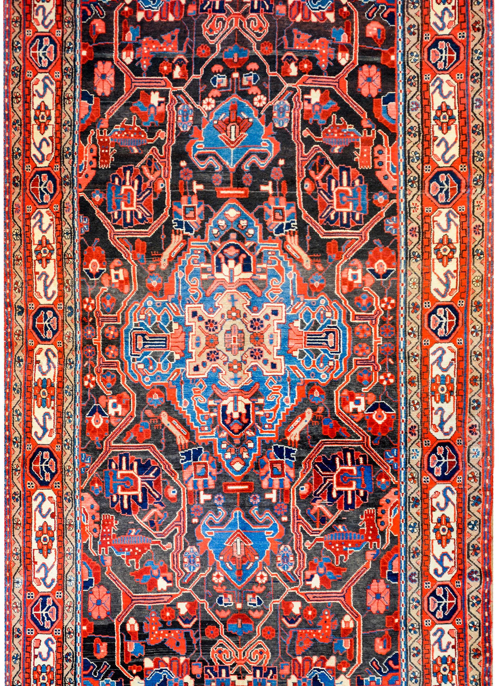 A fantastic vintage Persian Mezlaghan rug with a large central indigo diamond medallion with myriad stylized flowers woven in salmon, coral, crimson, and light and dark indigo. The medallion lives amidst a field of more stylized flowers on a black