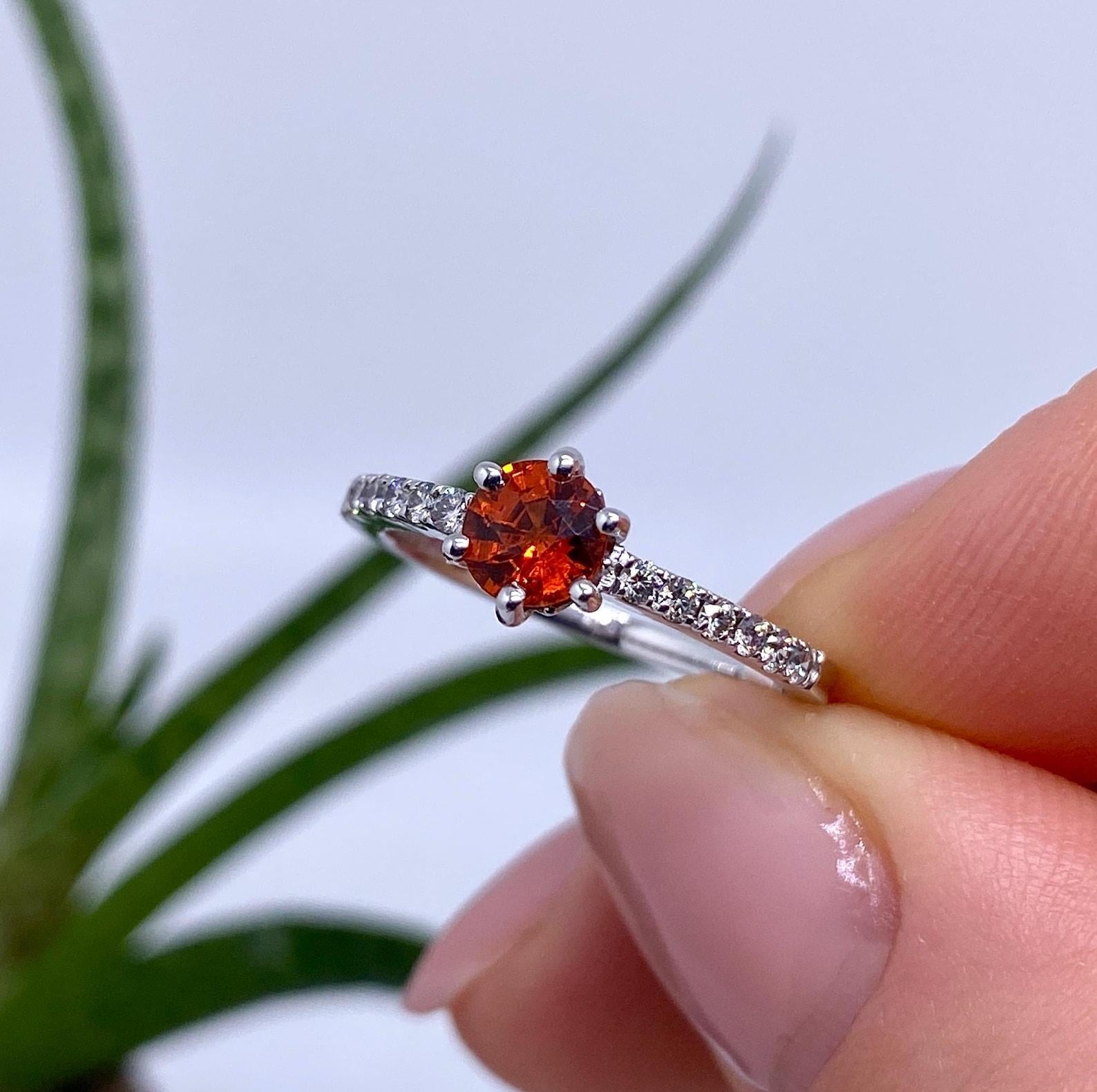 Gema natural de espesartita y diamantes
Anillo de oro blanco de 14 quilates

Certificado completo de laboratorio para el anillo.
Piedra principal: Granate Spessartine
Creación de la piedra principal: Natural
Color de la Piedra Principal:
