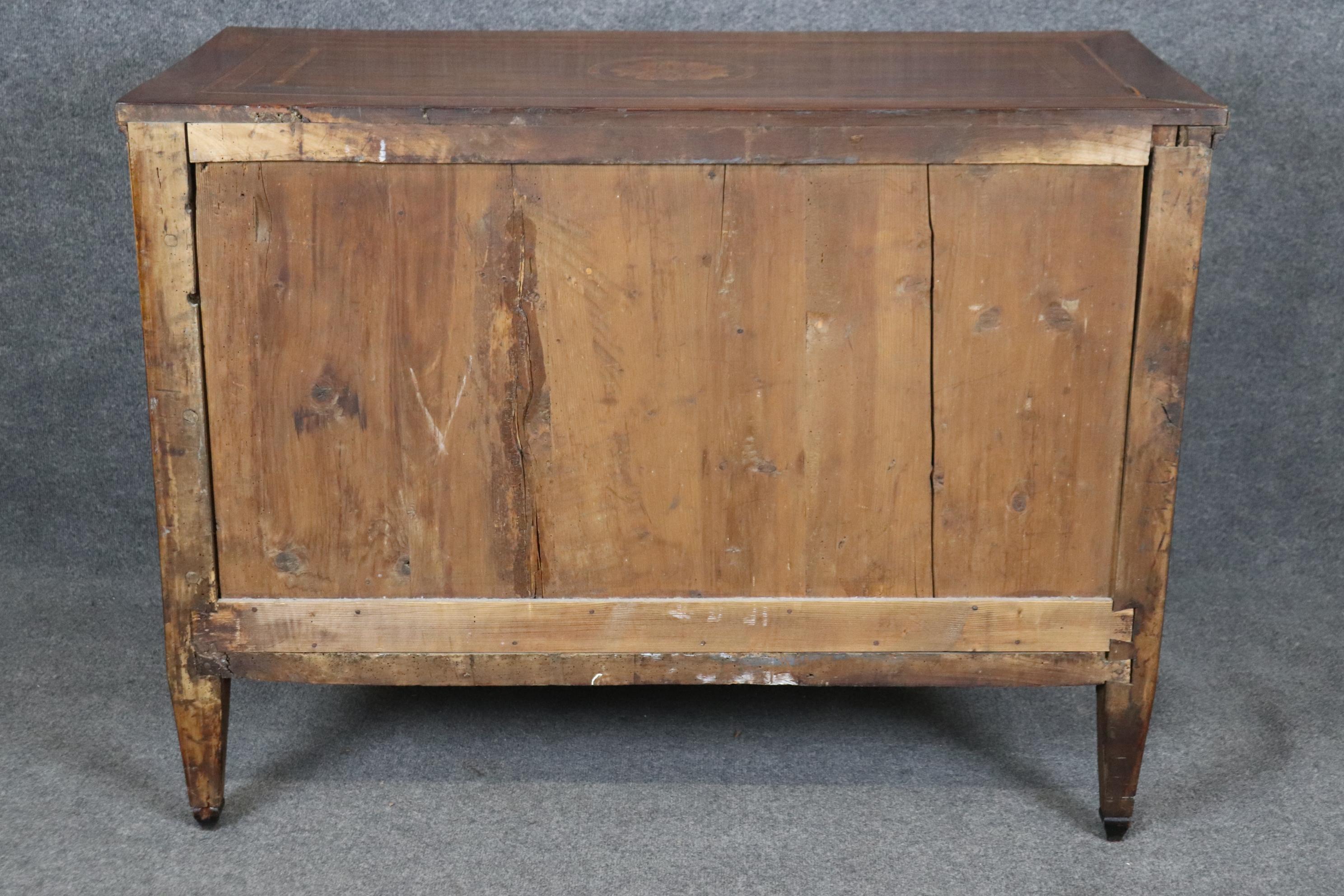This is a rare find indeed. The piece shown here is a much higher form of Italian-made commode than most we see or have and has the hottest styling of those days in Europe- French Directoire. The commode is covered in gorgeous flame walnut veneer