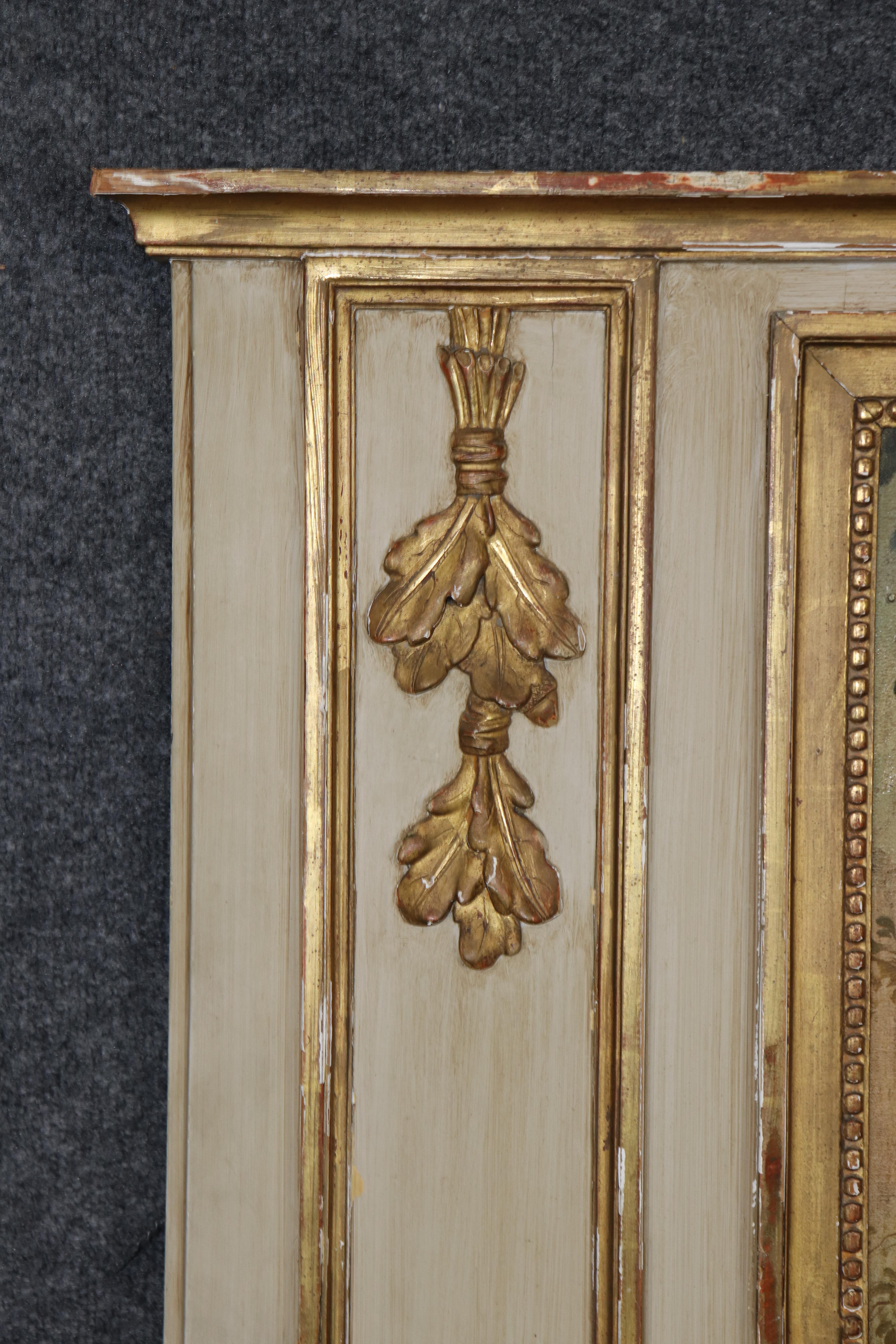 This gorgeous and quite large Trumeau mirror was made in France and has a creme painted frame and groegous gold leaf time-wron highlights. The mirror features an oil-on-board courtship scene and is romatic and superbly well done. The condition is