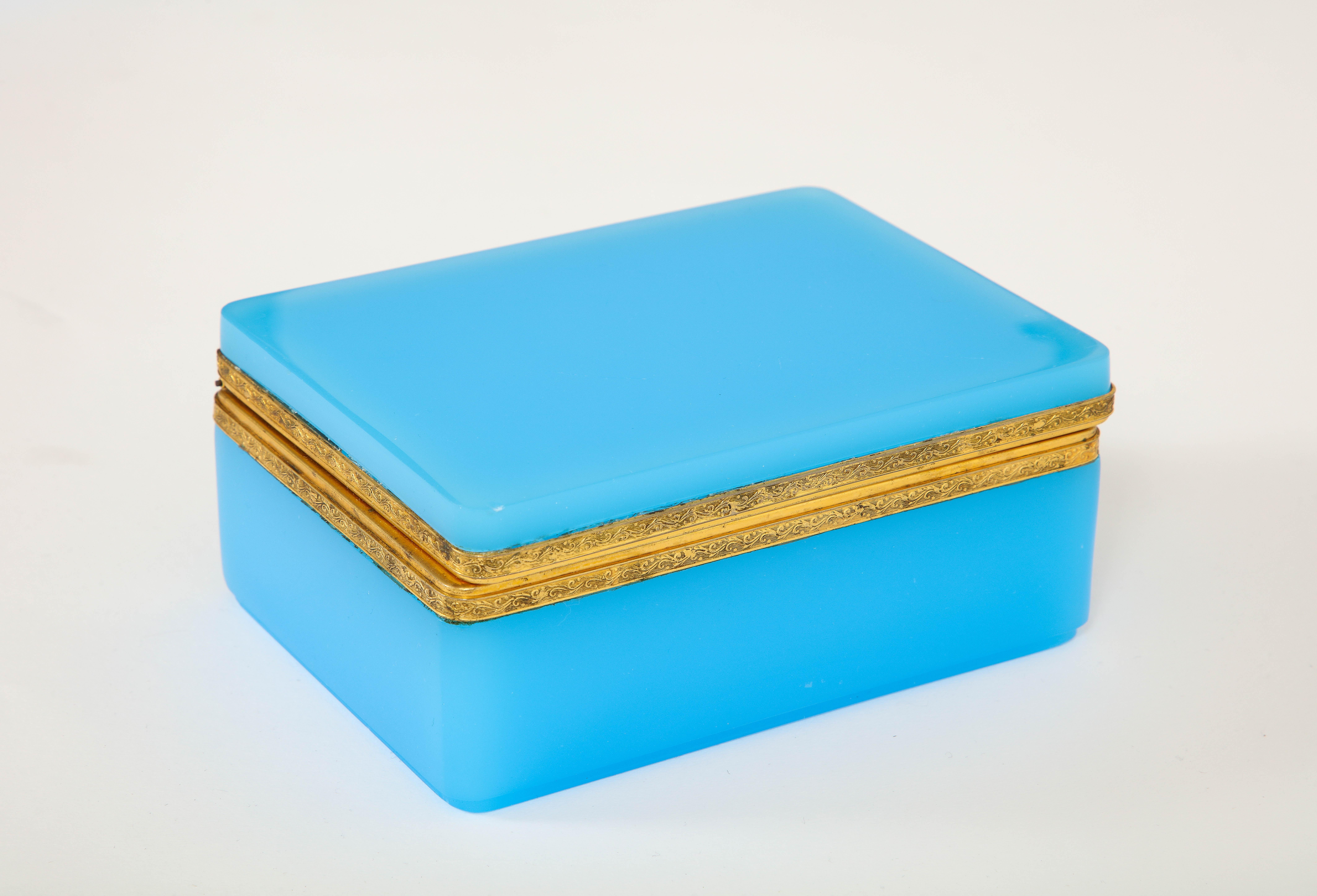 Fantastique boîte en cristal opalin bleu montée en bronze doré, de style Louis XVI, datant du 19e siècle.  La boîte est composée de deux sections de cristal opalin français qui sont montées sur un fabuleux loquet en bronze doré.  Le bronze de la