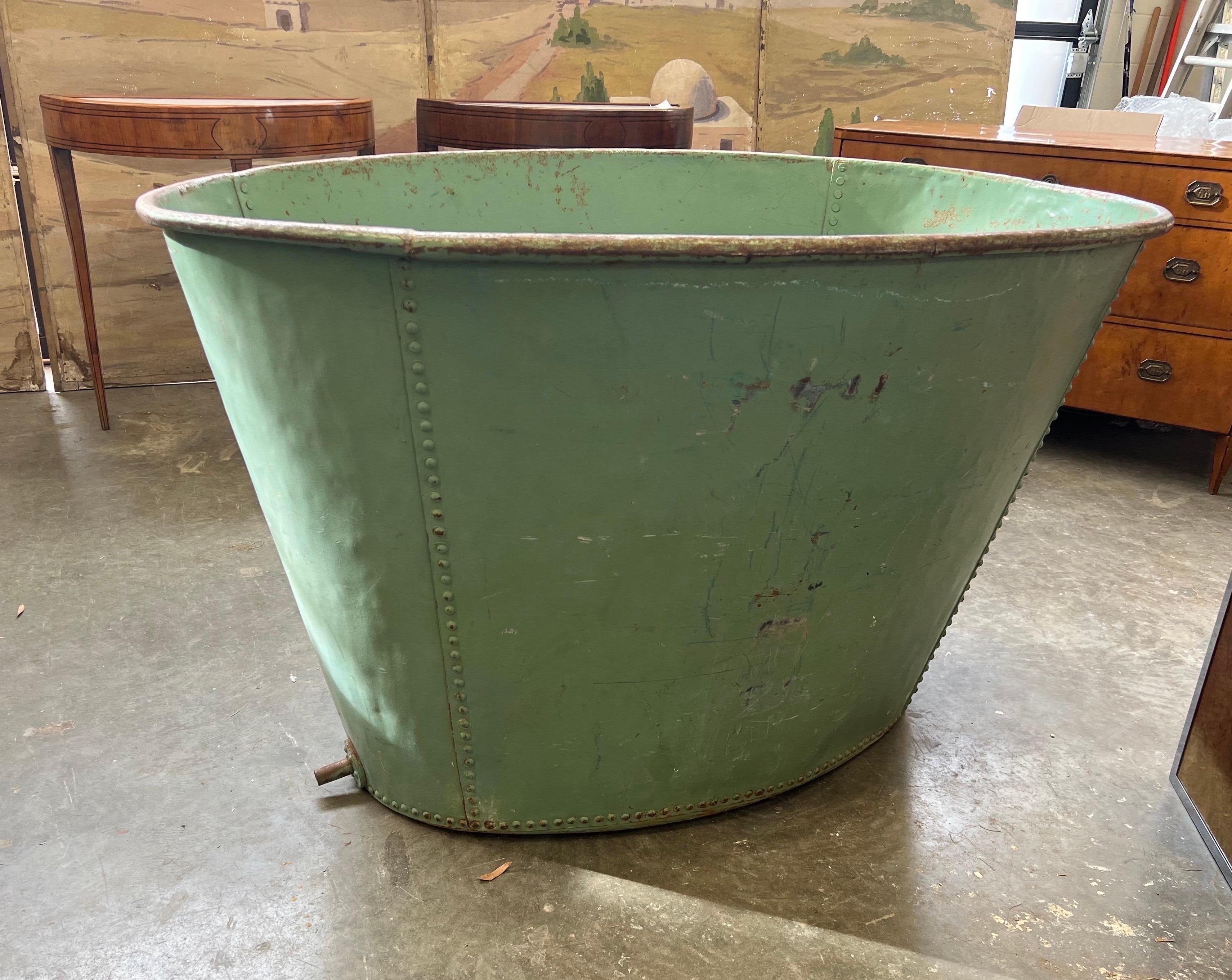 Fantastic 19th century oversized painted French tub, probably used for grapes and winemaking. Hand hammered and riveted, painted green and working drain in the bottom. In addition to making a spectacular working tub, this would also be great as a