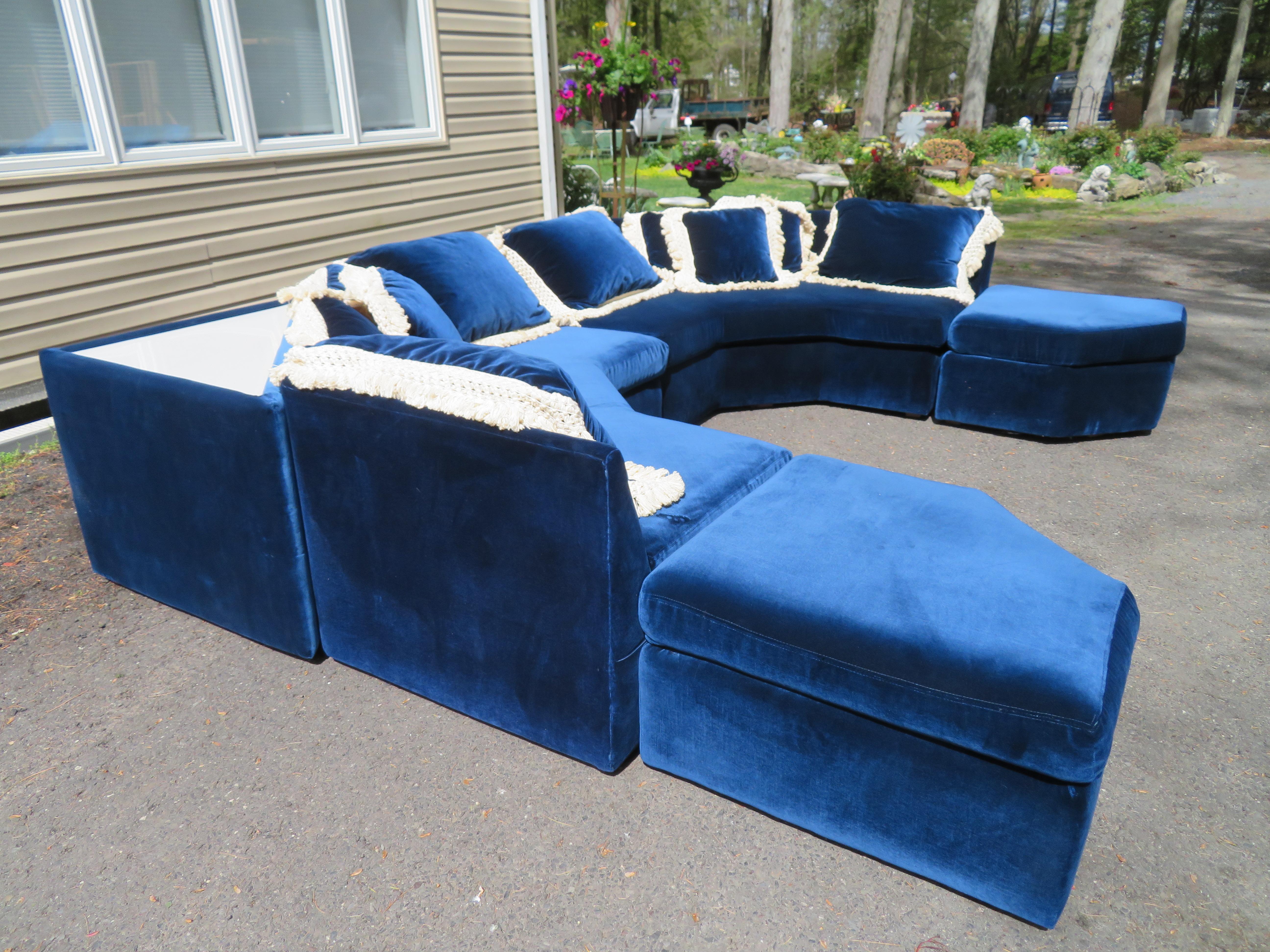 Fantastic deep blue velvet 2 piece angled sofa with 2 light-up tables and 2 ottomans, so this is a total of 6 pieces. This sofa sectional was made By Carsons and is the style of Milo Baughman. The triangular tables light up and look amazing with the